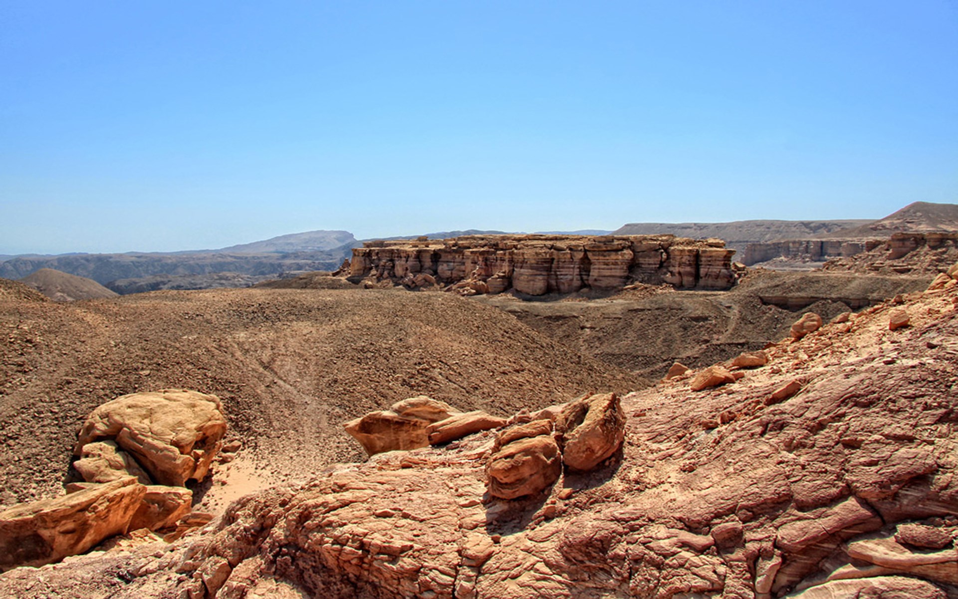 Desert landscape with rock formations and clear blue sky HD Wallpaper