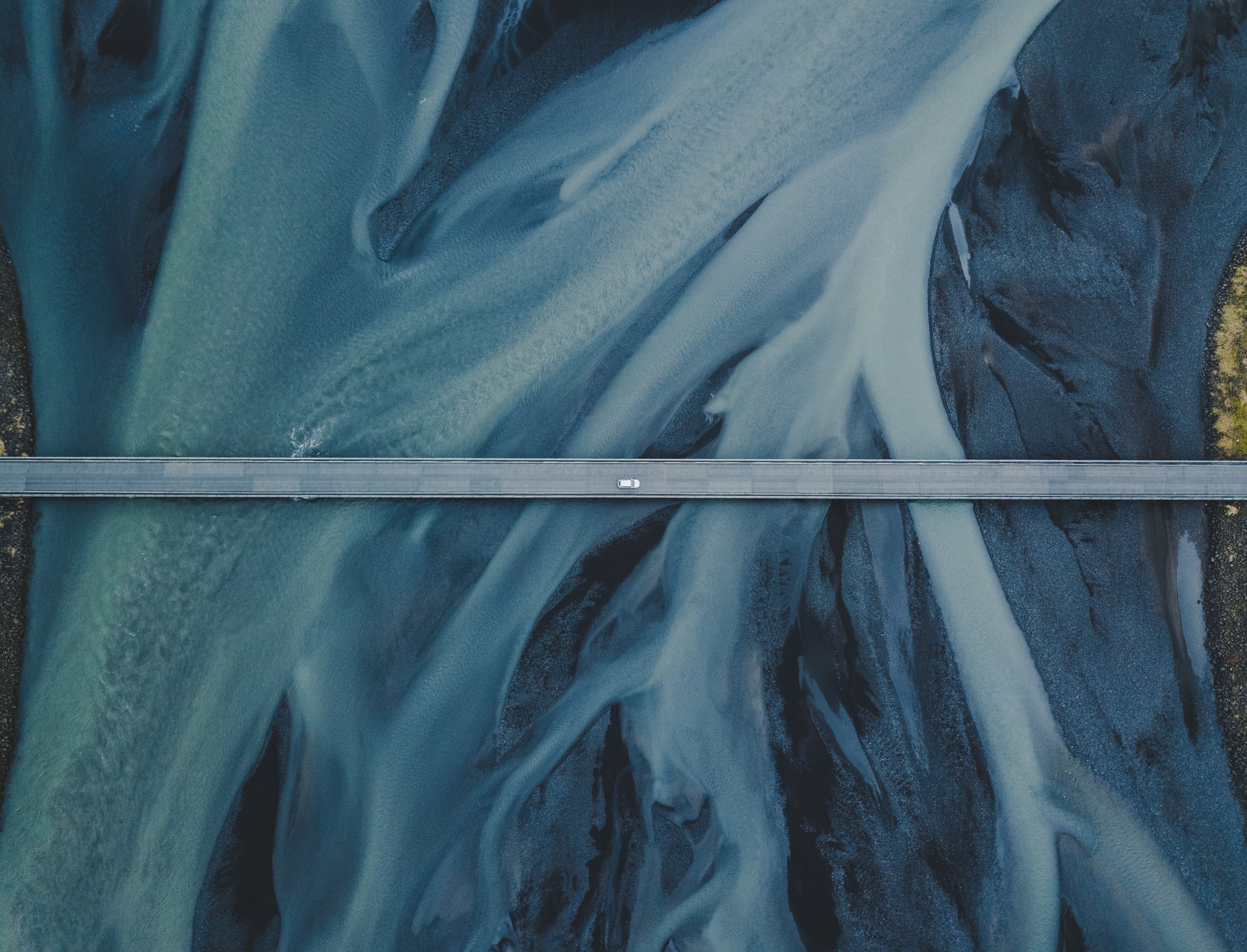 Aerial view of a bridge over a river with a vehicle HD Wallpaper