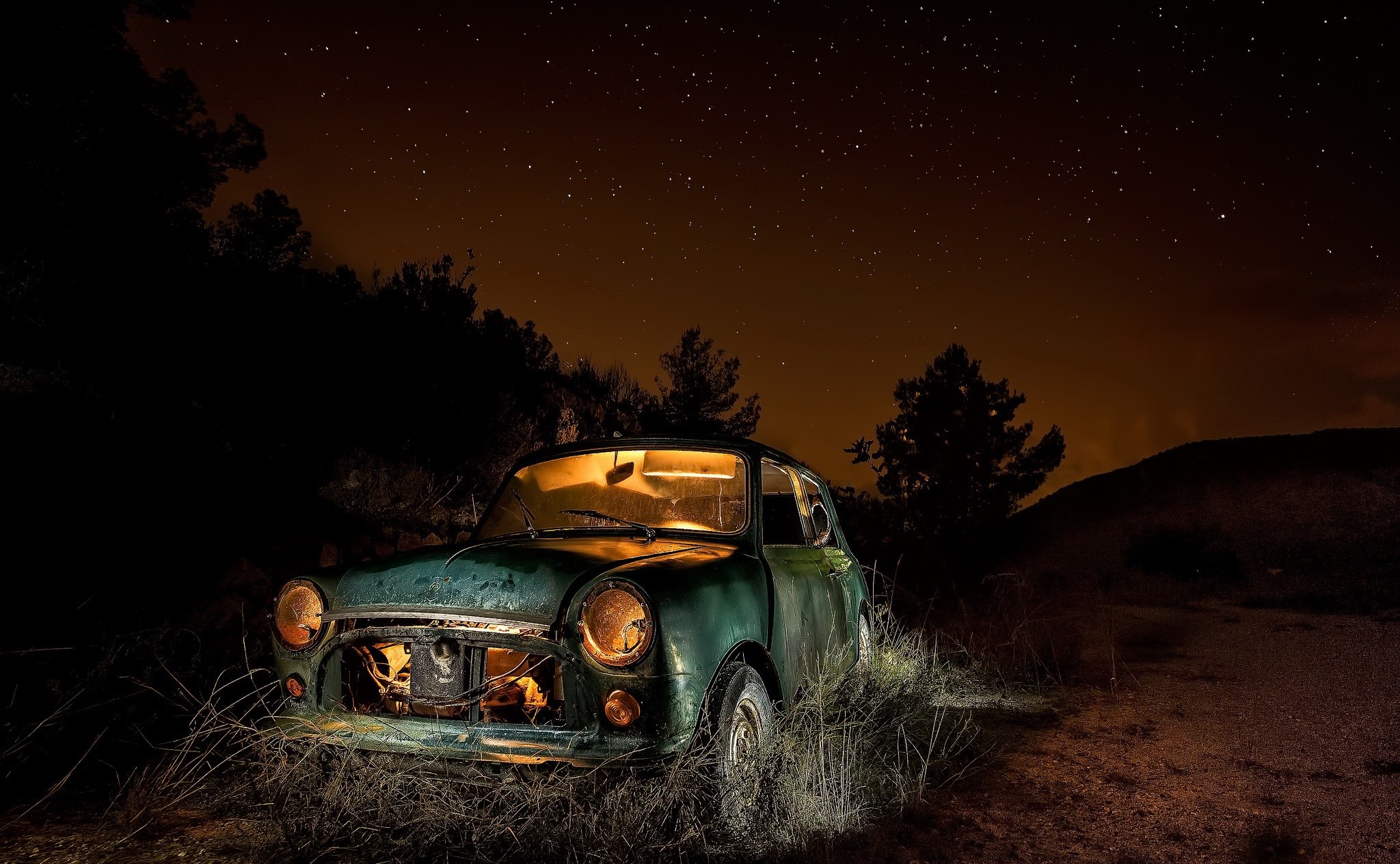 Abandoned car at night under starry sky HD Wallpaper