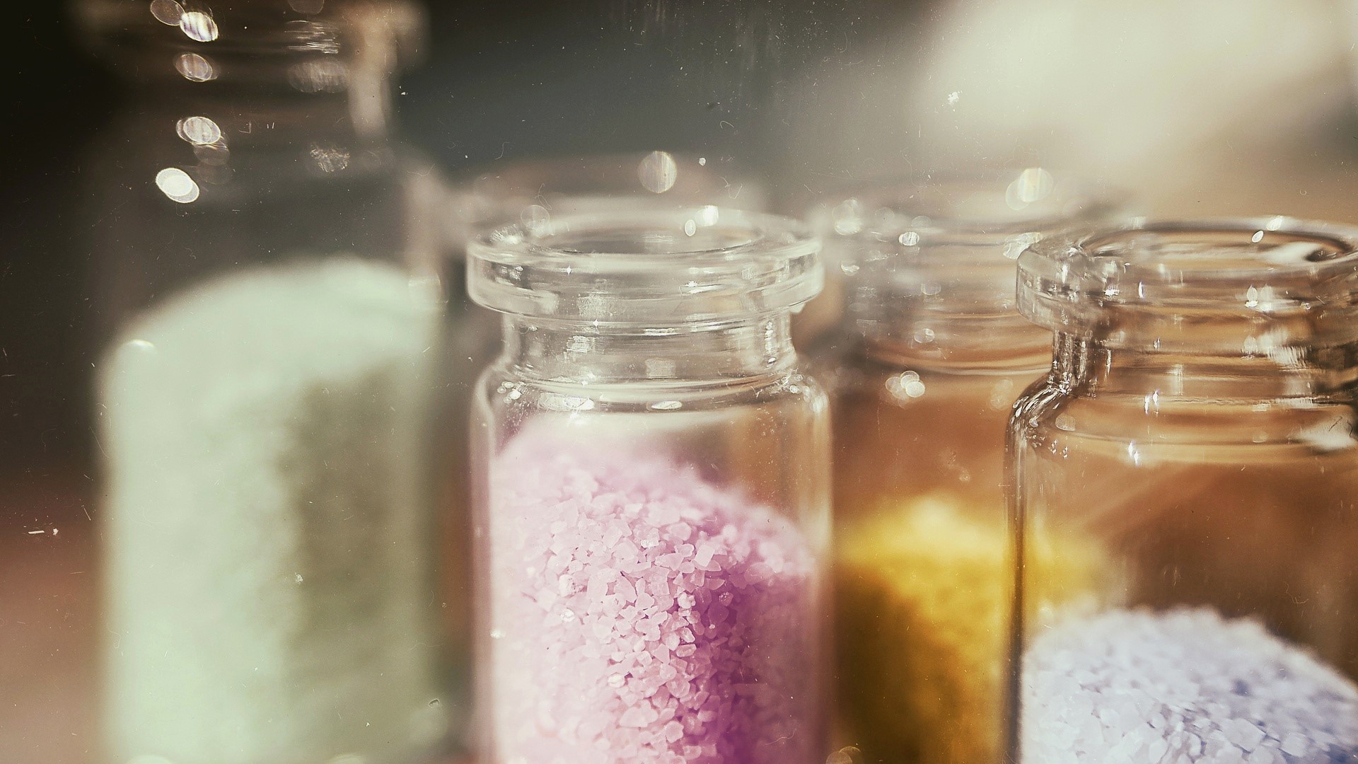 Close-up of colorful bath salts in glass bottles HD Wallpaper