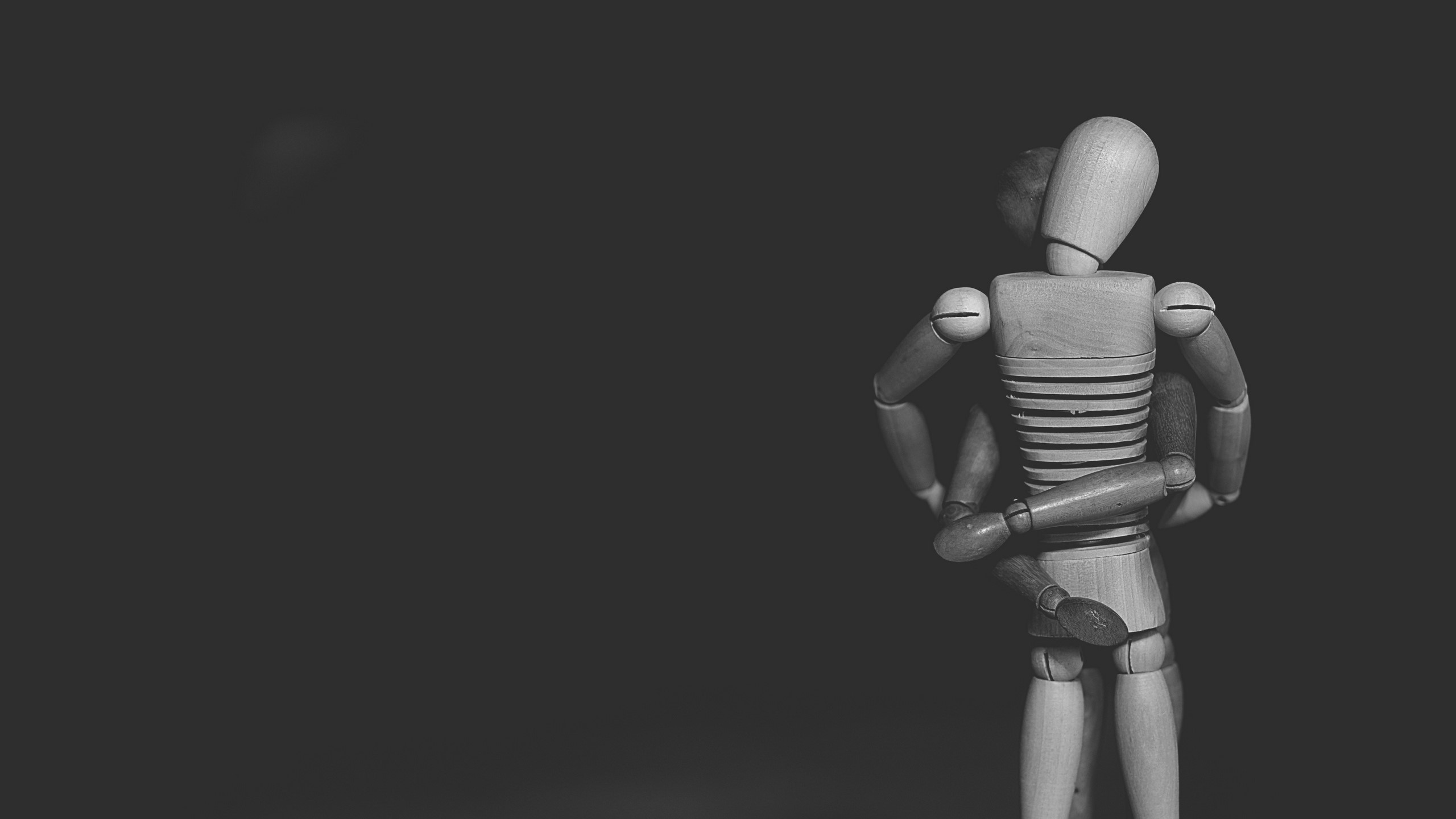 Two wooden mannequins in a hug HD Wallpaper