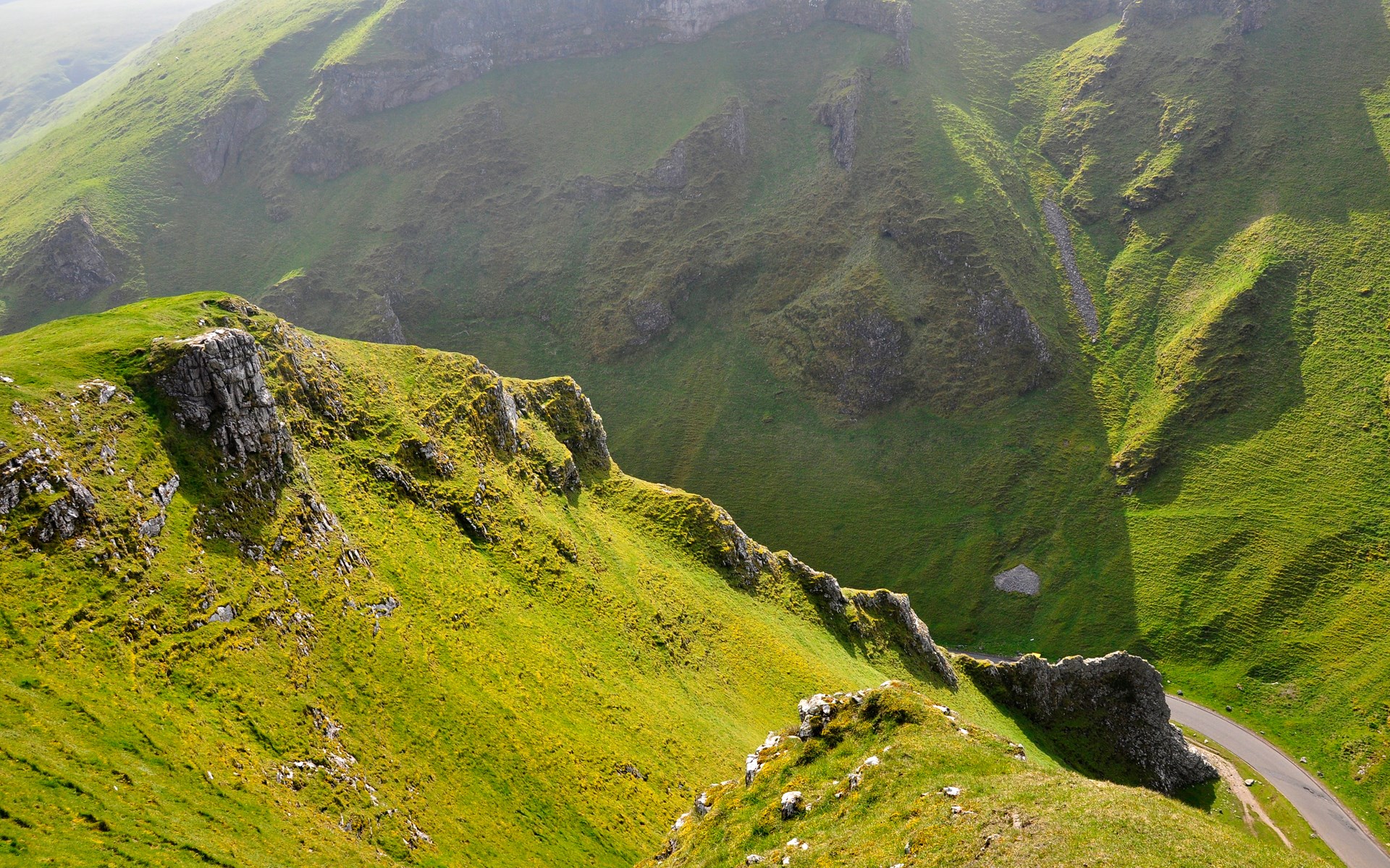 Green rolling hills with a winding road HD Wallpaper
