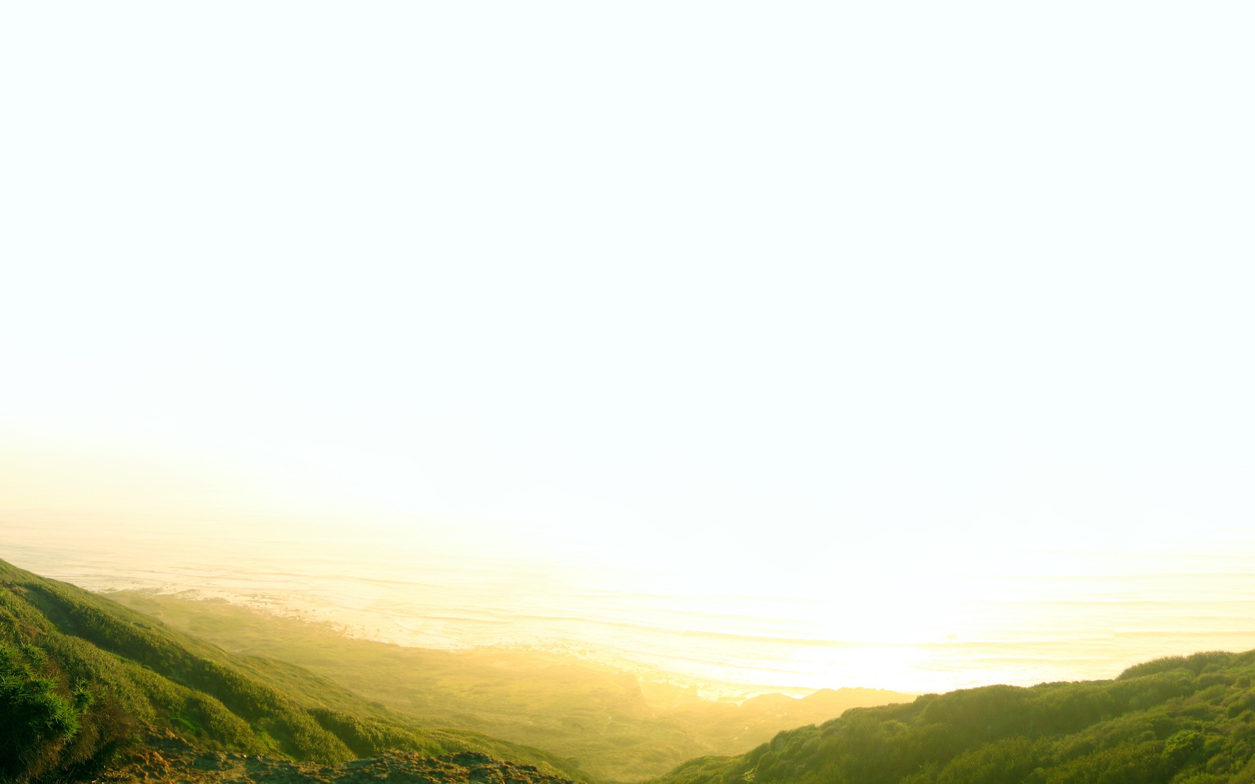 Green hills overlooking the sea at sunset HD Wallpaper