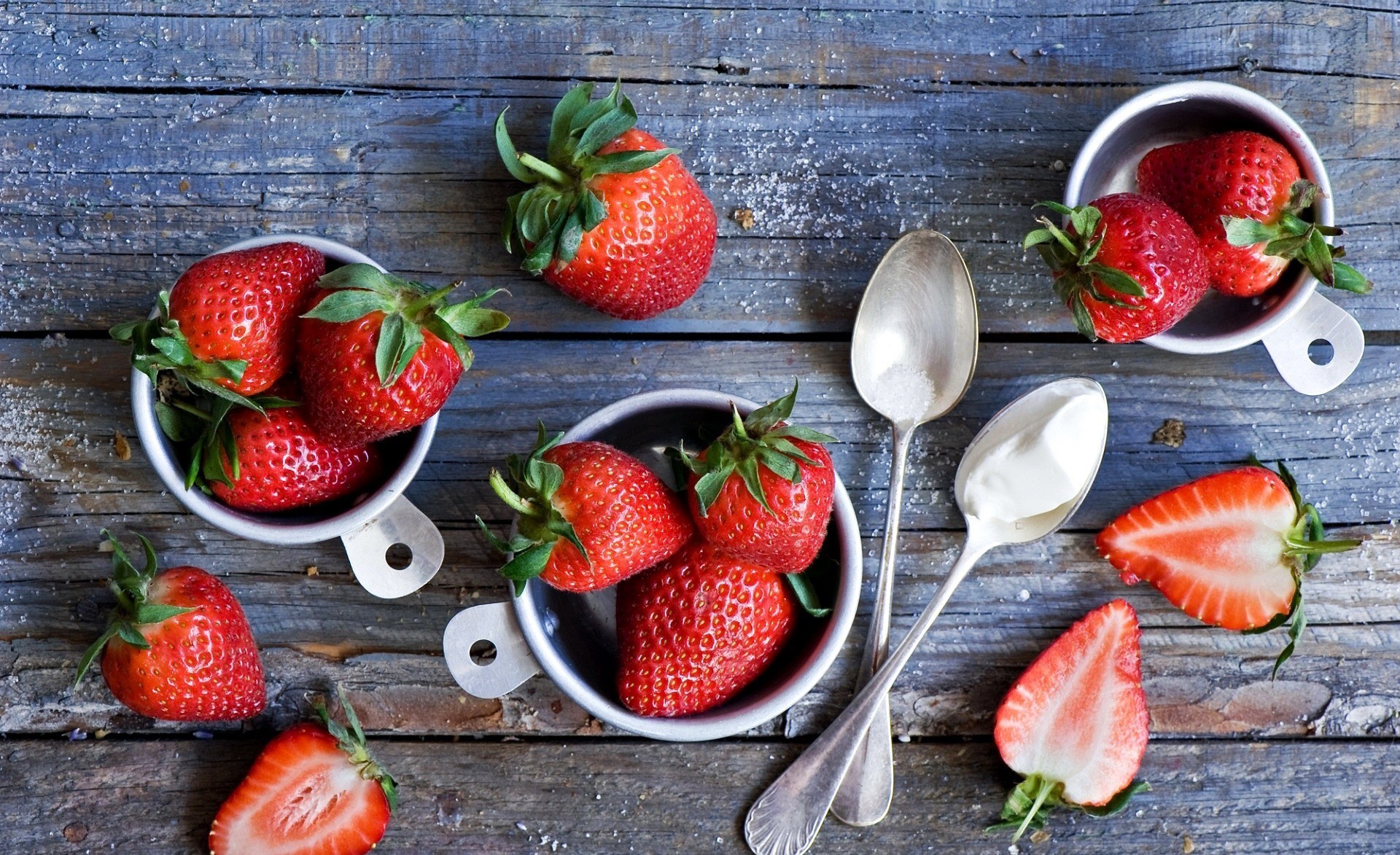 Strawberries and cream with spoons on a wooden table HD Wallpaper