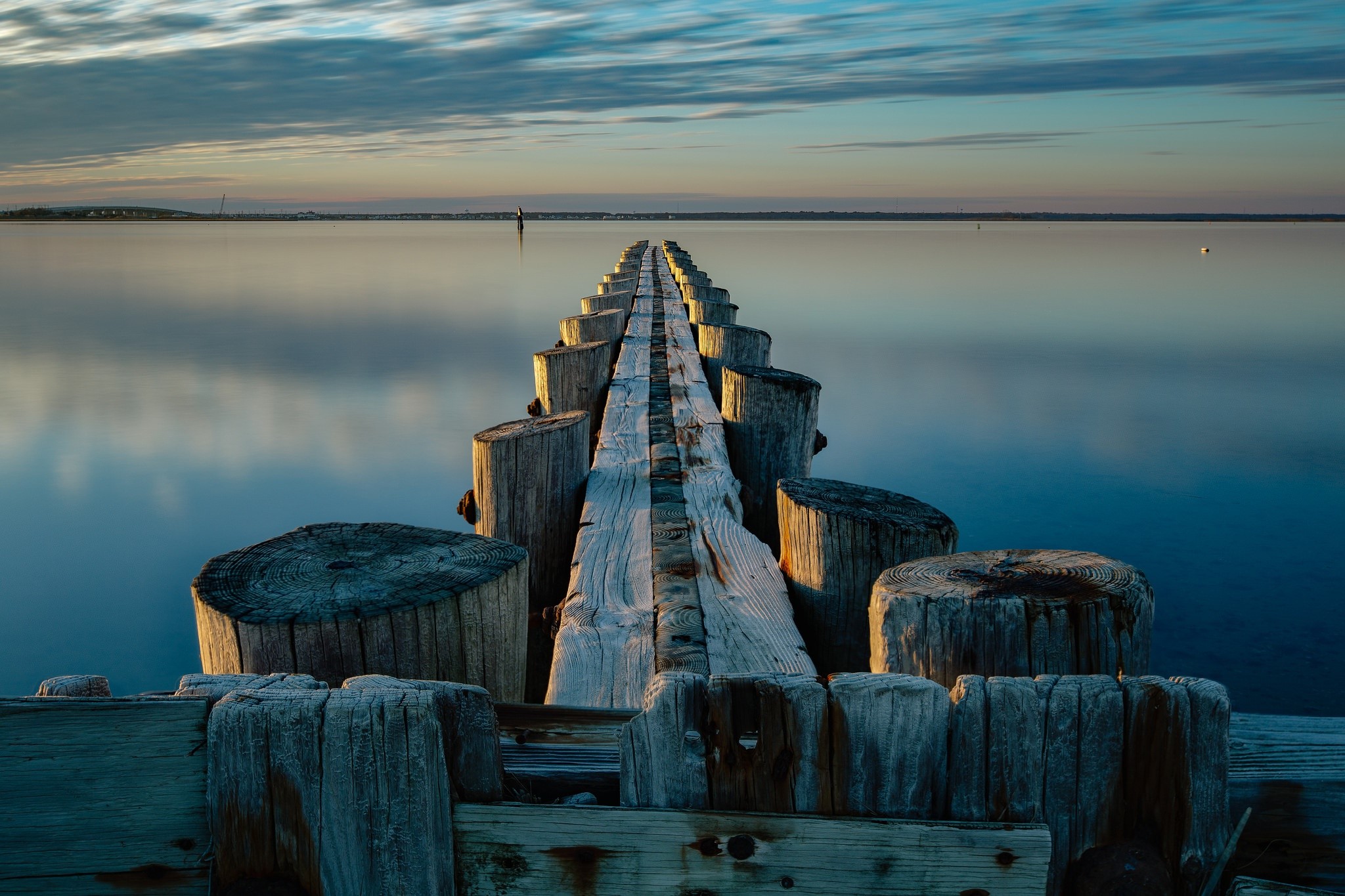 Wooden pier extending into calm water at sunset HD Wallpaper