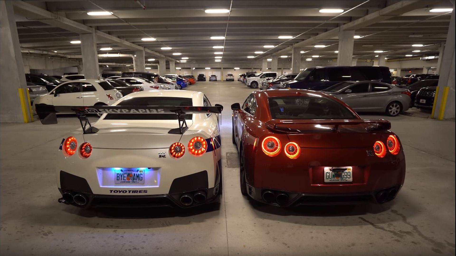 Two Nissan GT-R cars in a parking garage HD Wallpaper