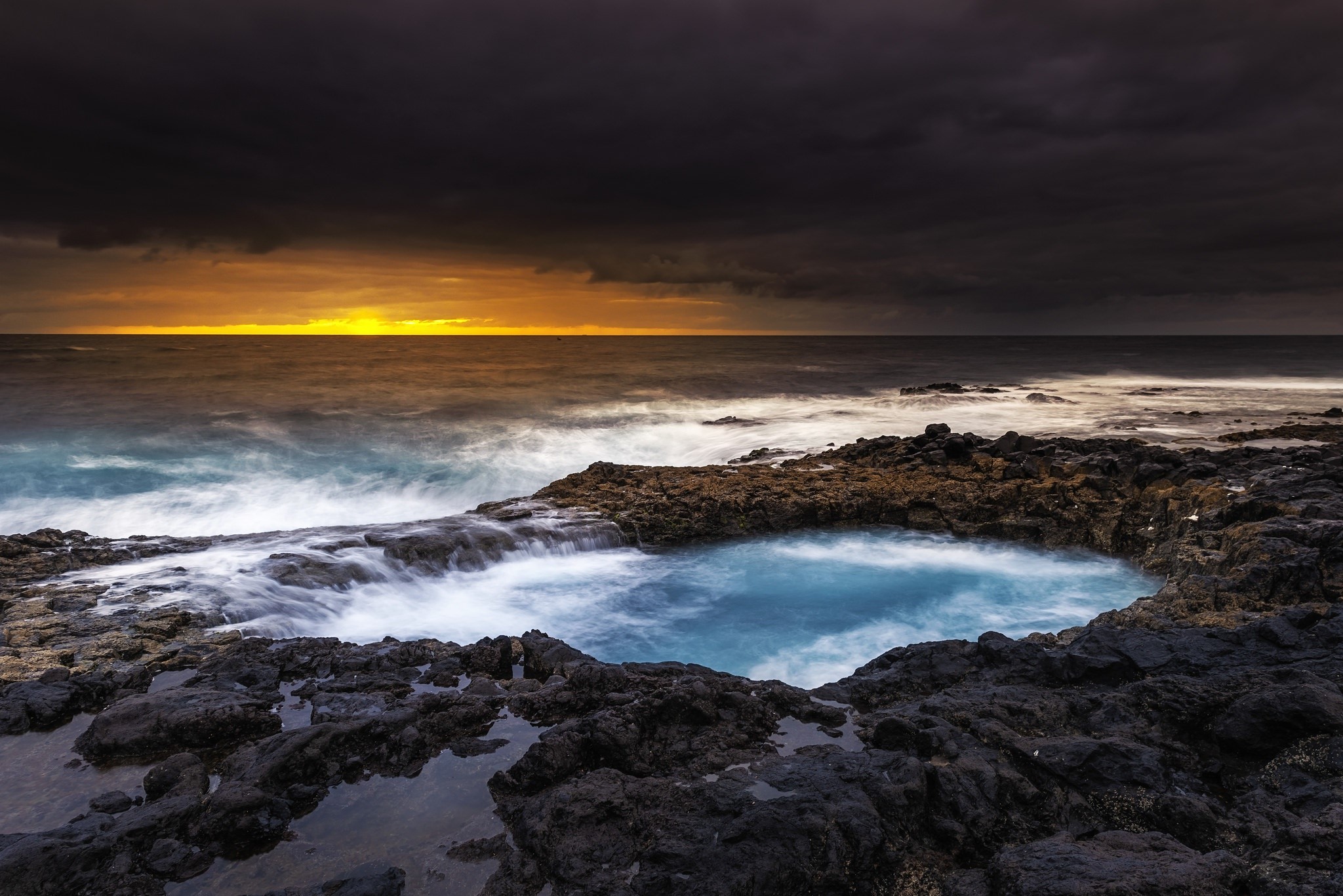 Ocean waves crashing on rocky shore at sunset HD Wallpaper