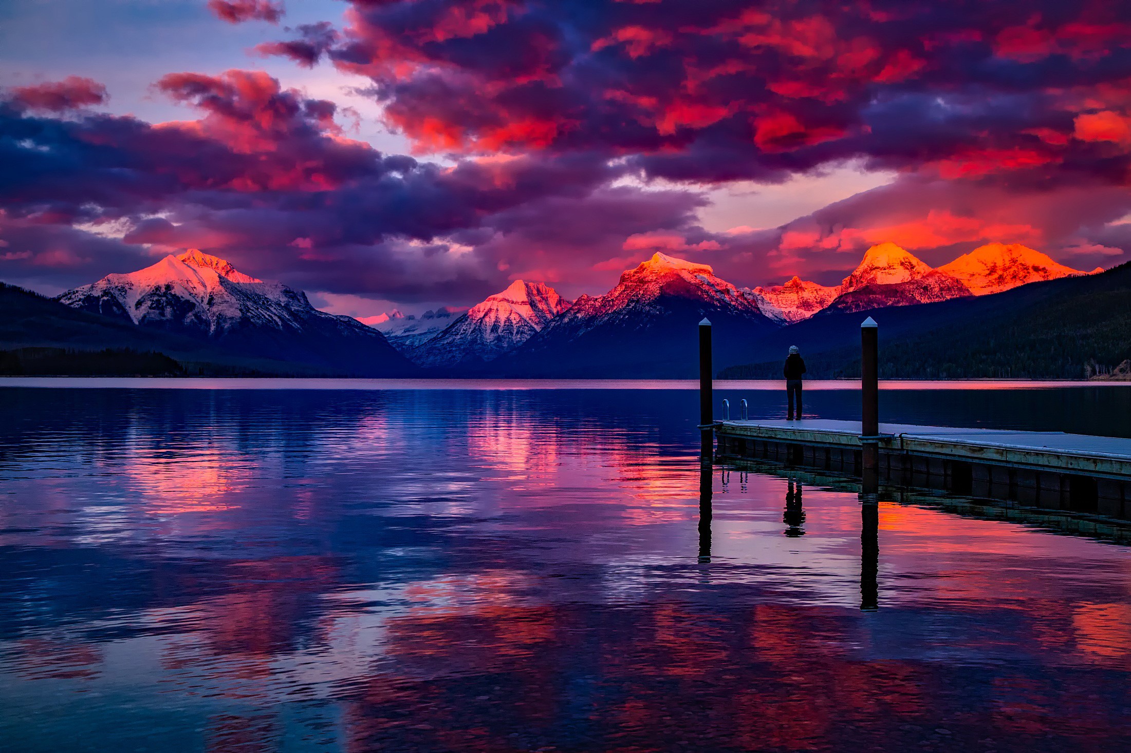Sunset over snow-capped mountains and a lake with a pier HD Wallpaper