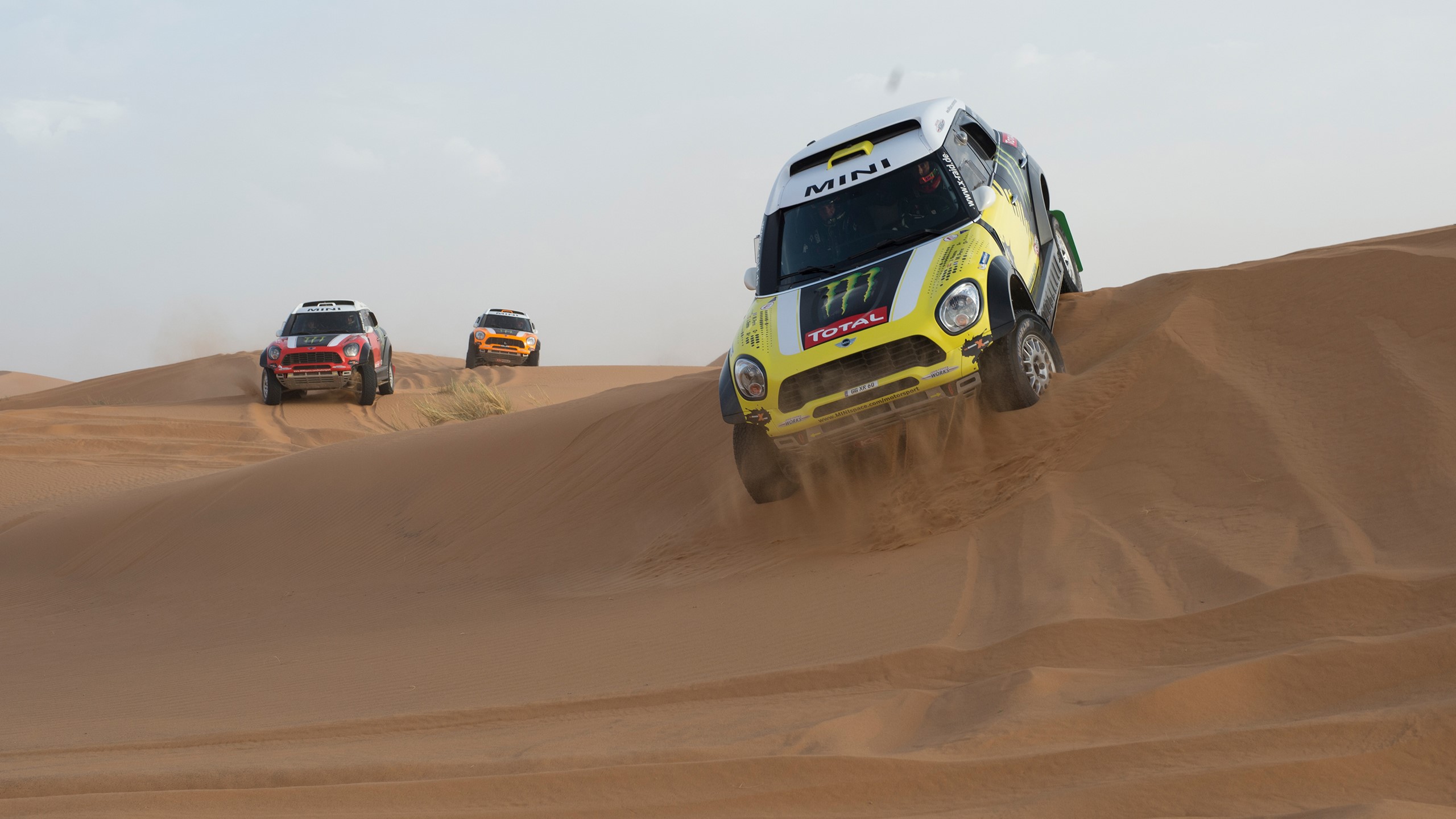 Mini Cooper rally cars racing on desert dunes HD Wallpaper