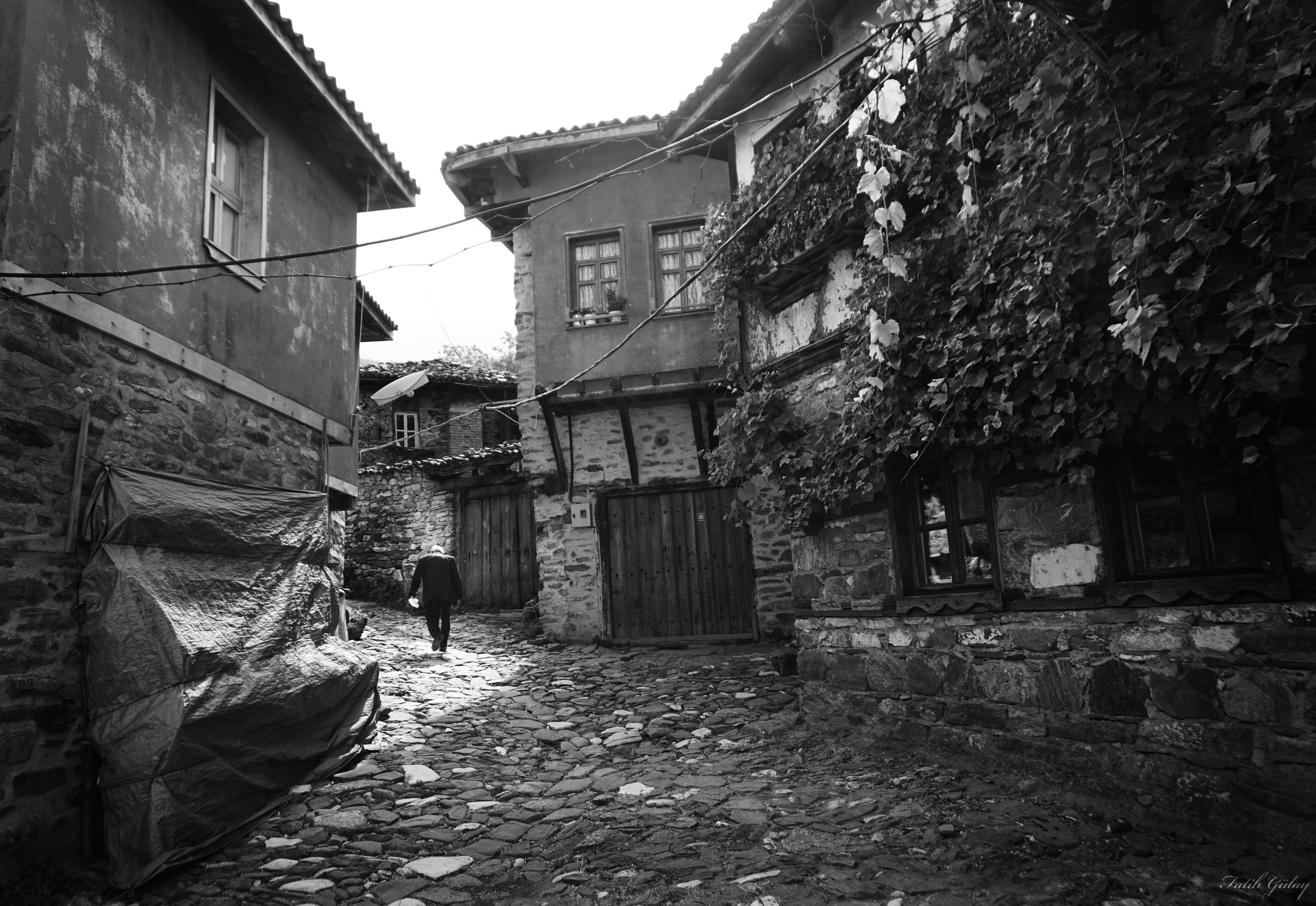 Monochrome village street with a person walking HD Wallpaper