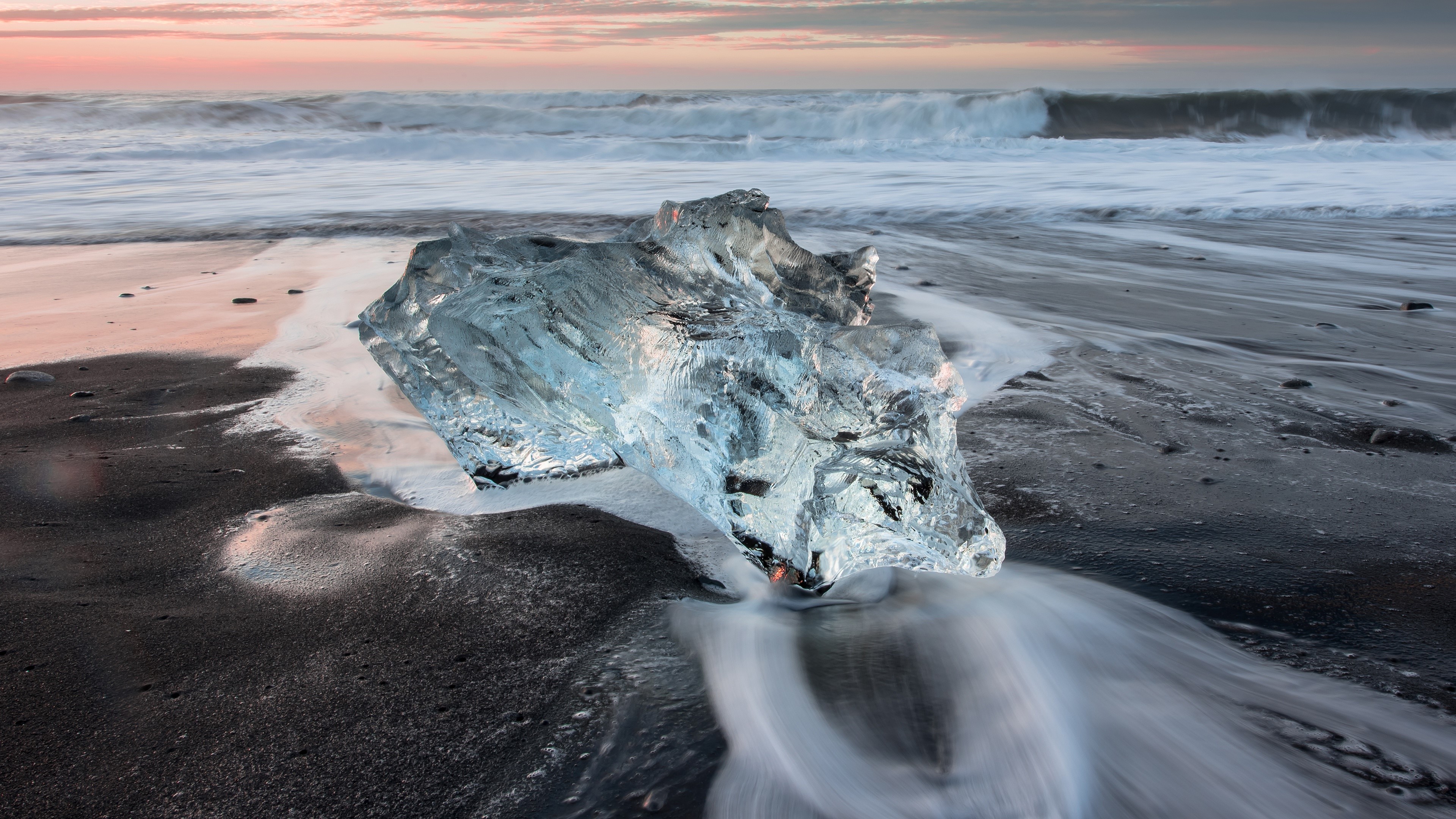 Ice on a black sand beach with waves HD Wallpaper