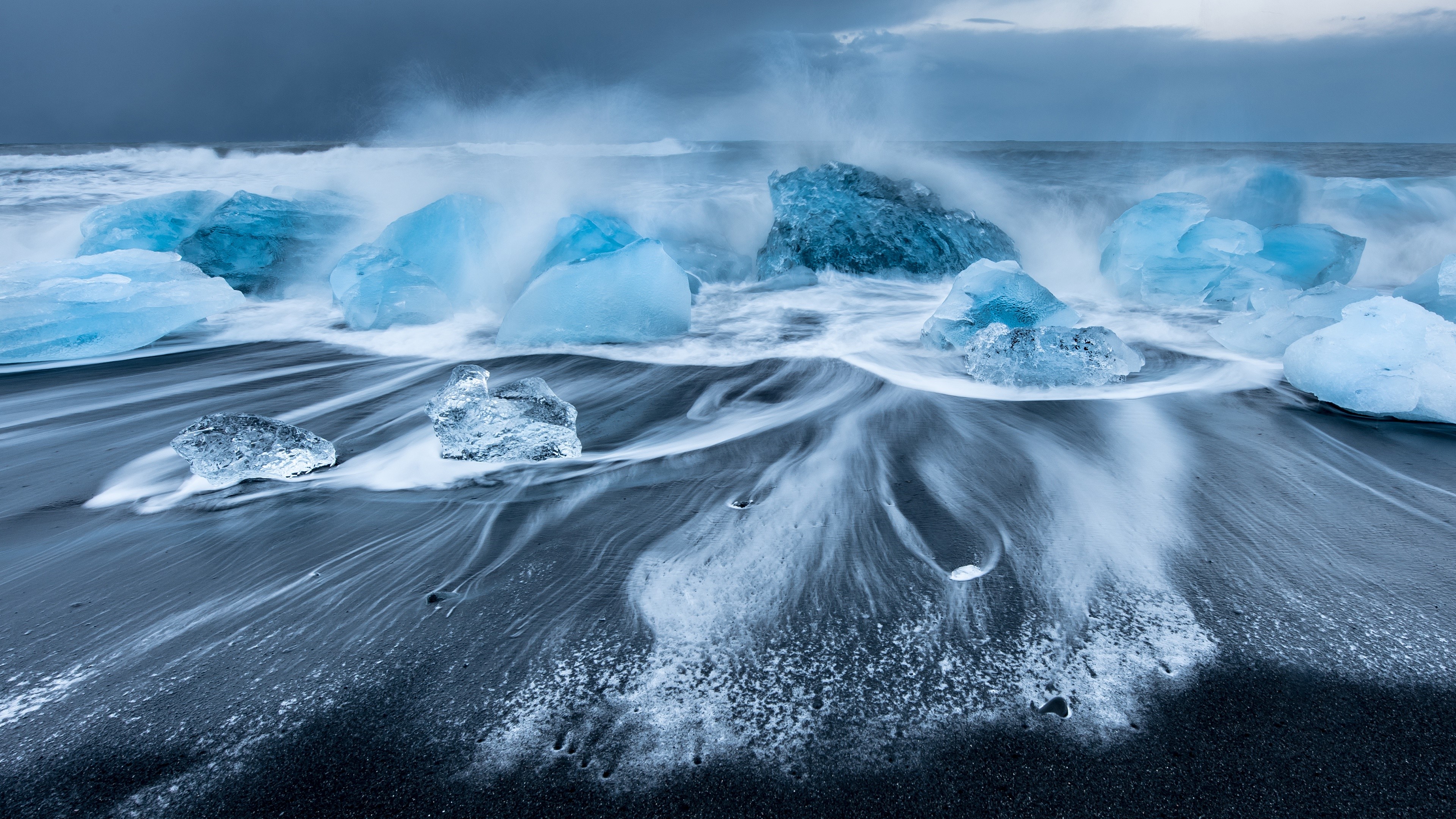 4K ice chunks on black sand beach with waves HD Wallpaper