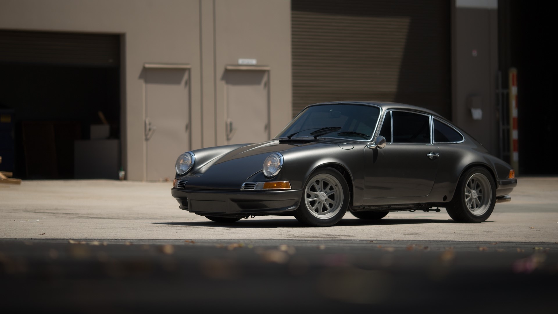 Dark gray Porsche 911 parked outside a building HD Wallpaper