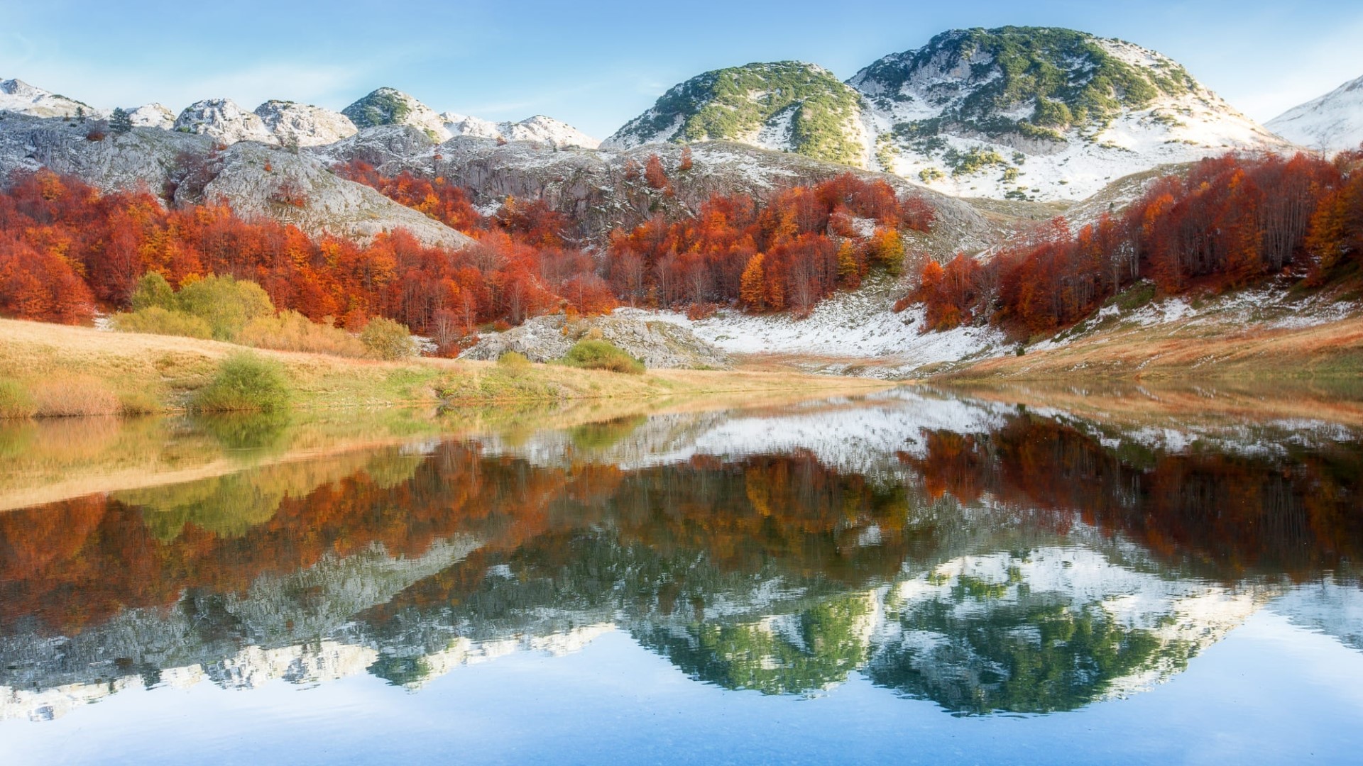 Autumn mountains reflected in a lake with snowy peaks HD Wallpaper