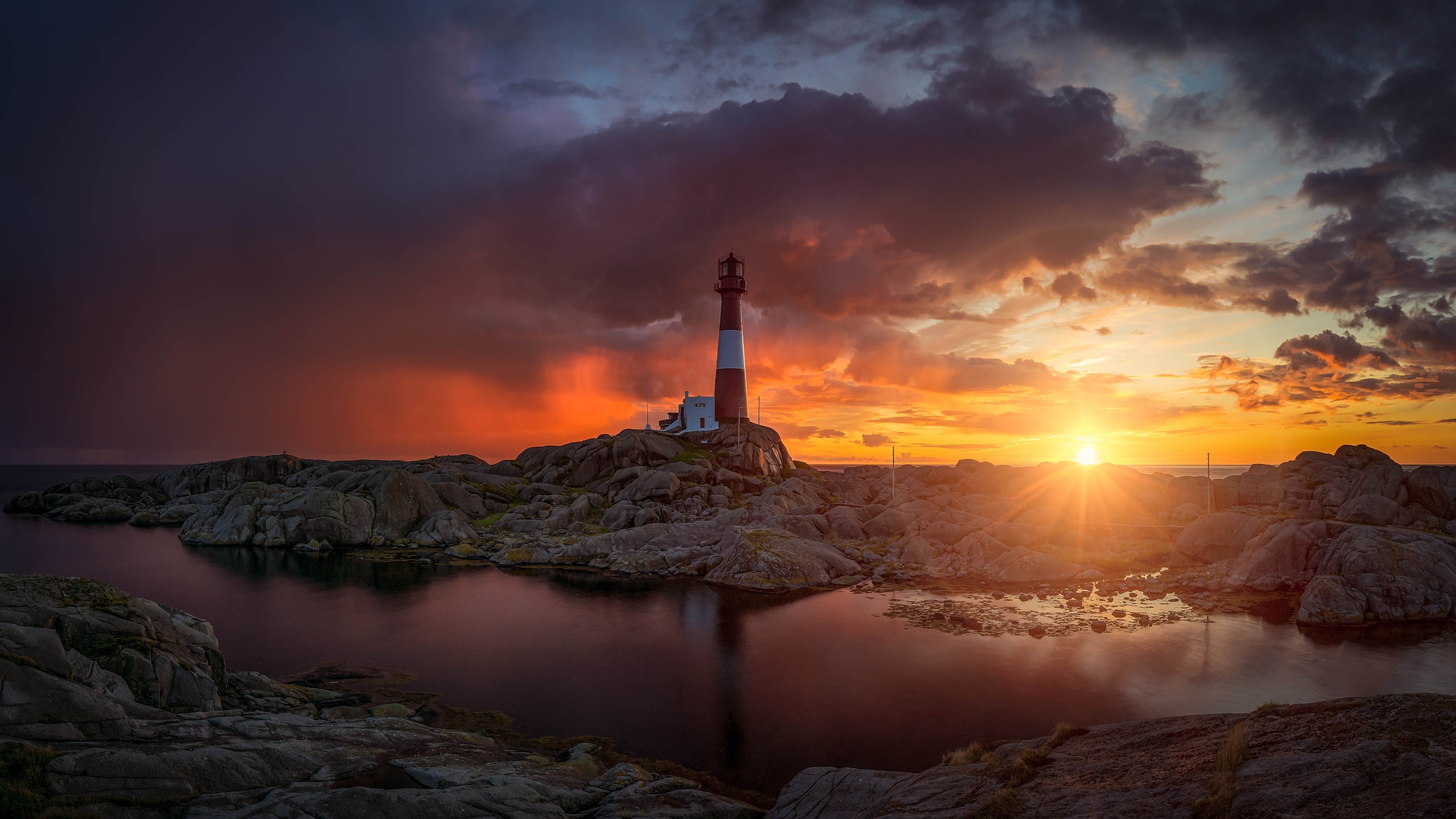 4K Lighthouse on Rocky Shore at Sunset HD Wallpaper