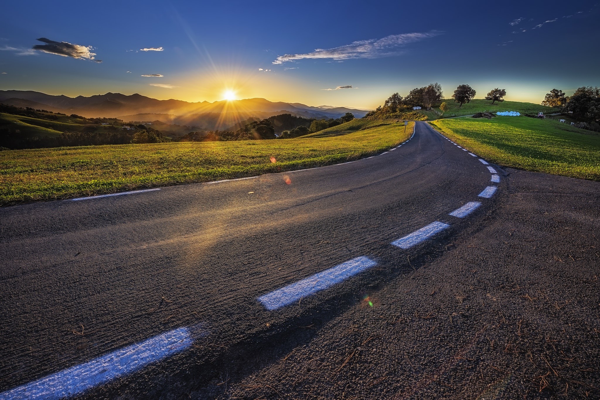 Road through rolling hills at sunset HD Wallpaper
