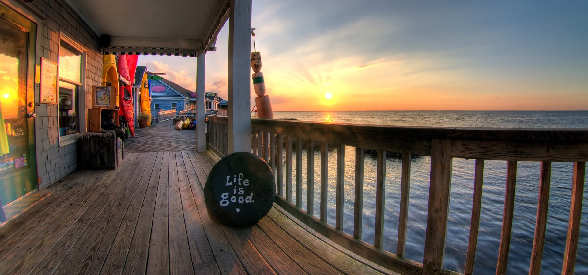 Sunset over the ocean from a wooden deck HD Wallpaper