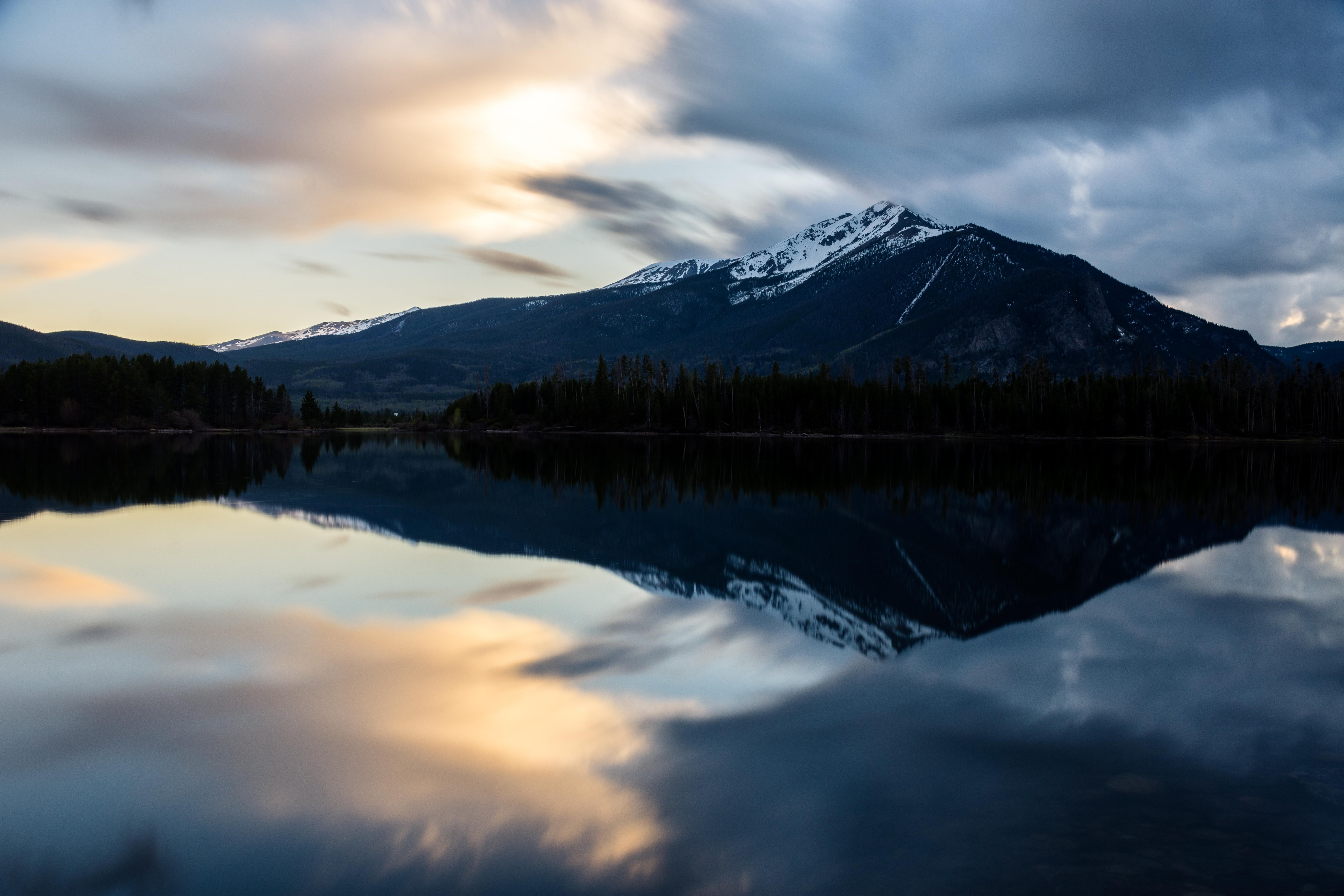 Snow-capped mountains reflected in a lake at dusk HD Wallpaper