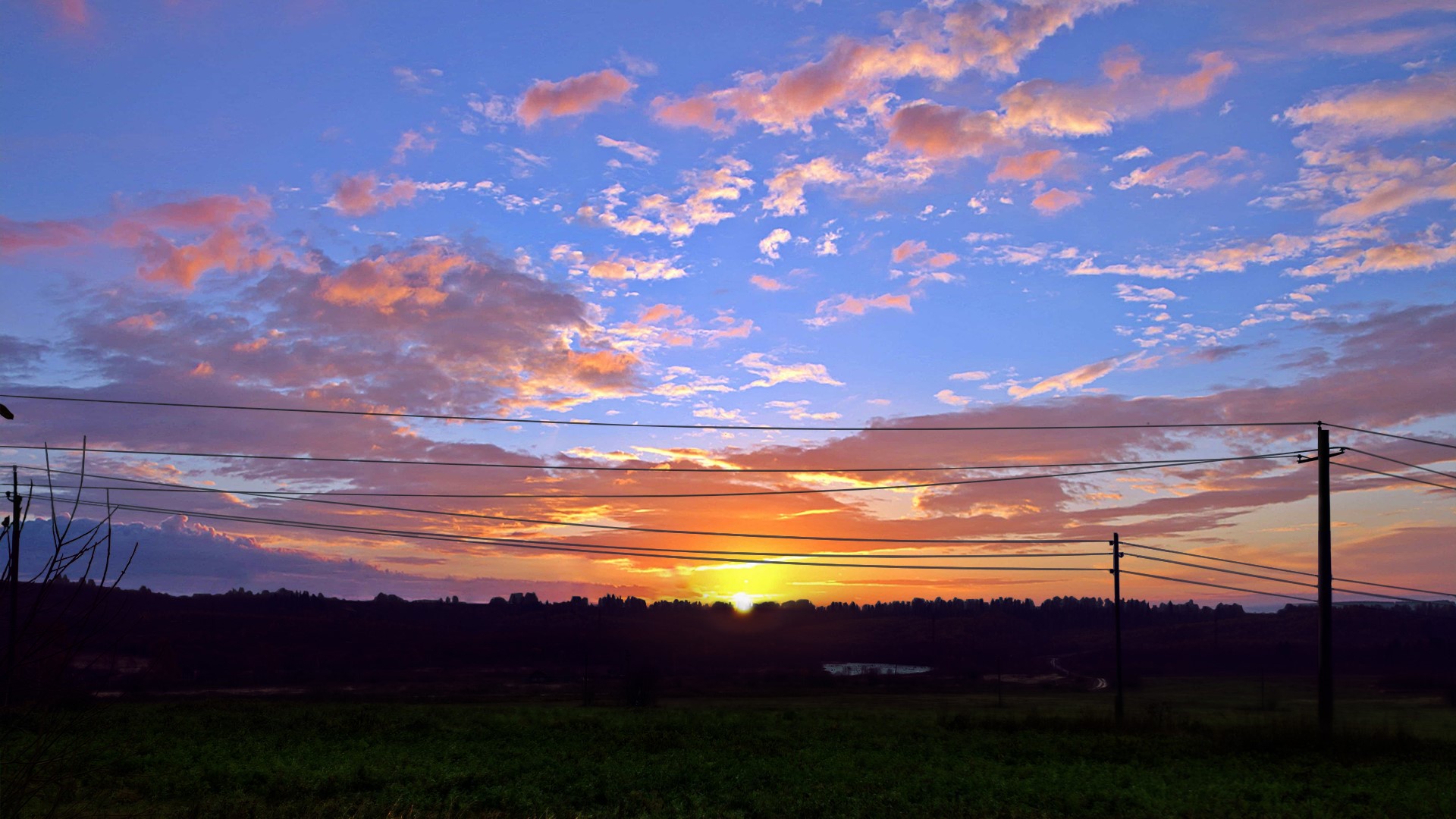 Sunset over a field with power lines HD Wallpaper