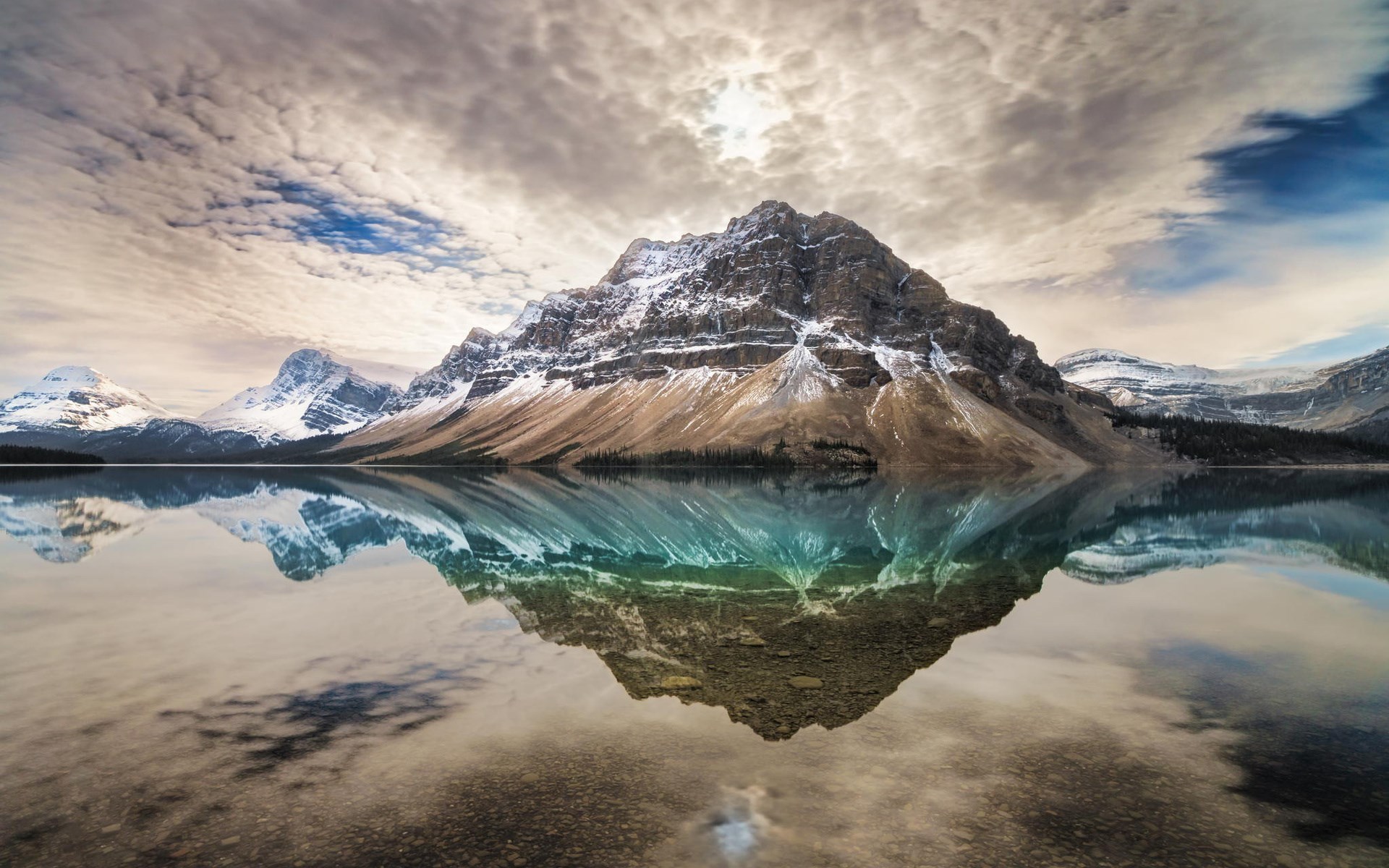 Mountain reflected in a calm lake under cloudy sky HD Wallpaper