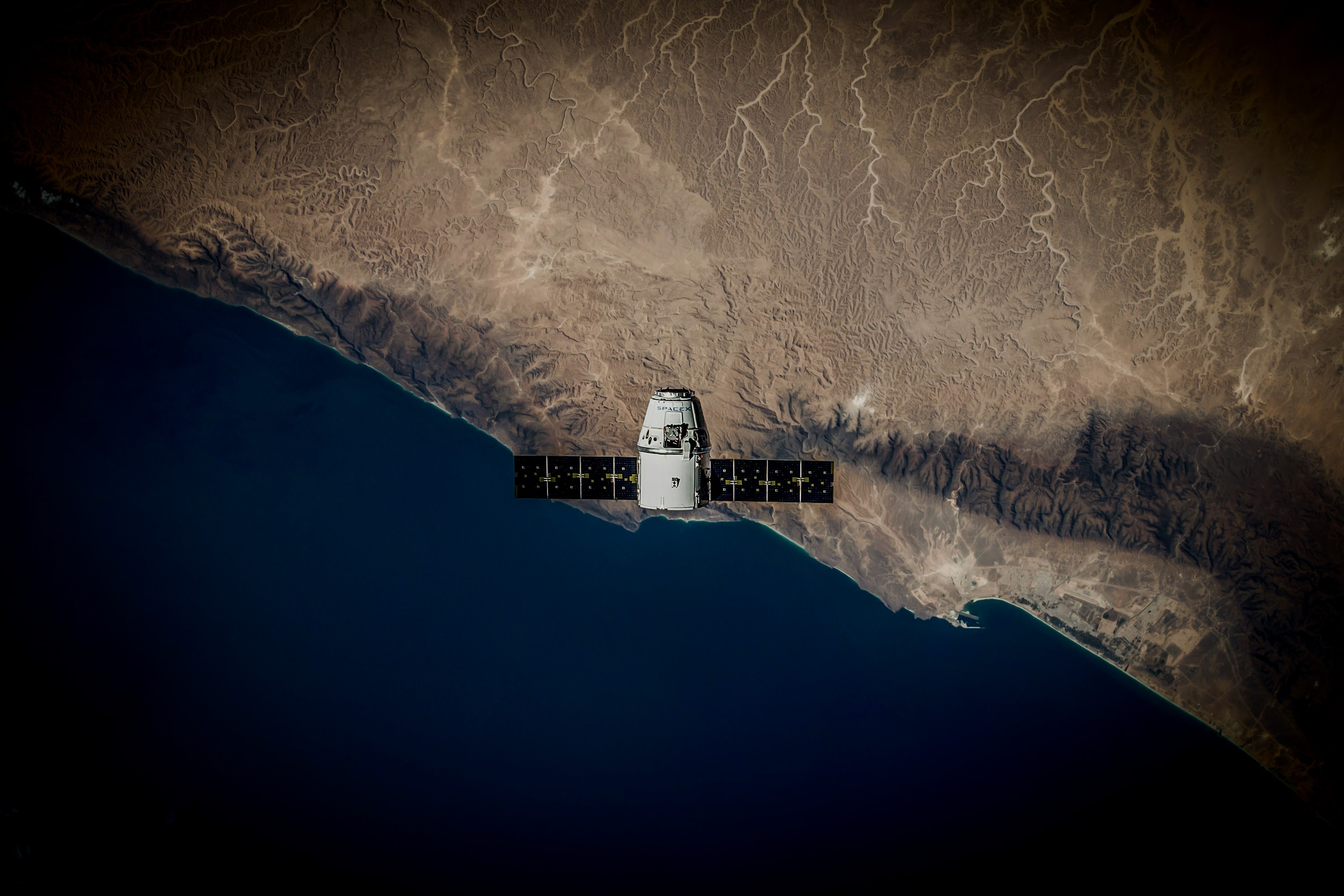 SpaceX Dragon spacecraft over Earth's coast HD Wallpaper