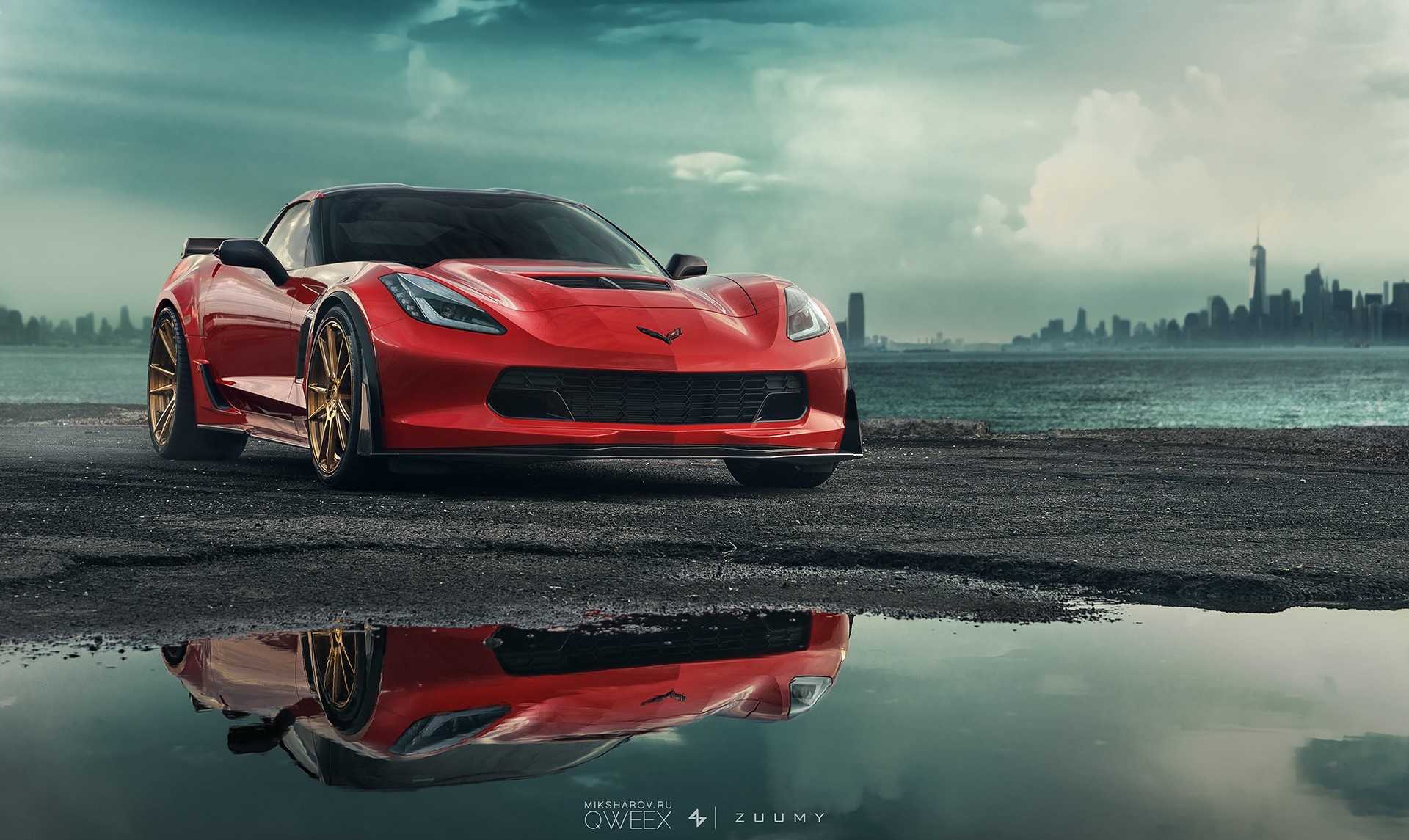 Red Chevrolet Corvette C7 parked by the water with city skyline HD Wallpaper