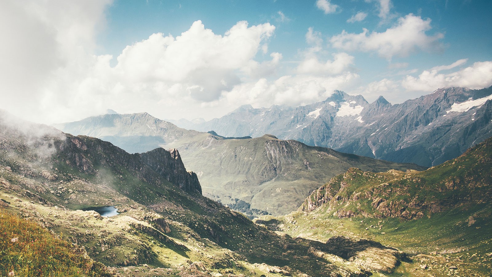 Mountains and clouds in a vast landscape HD Wallpaper