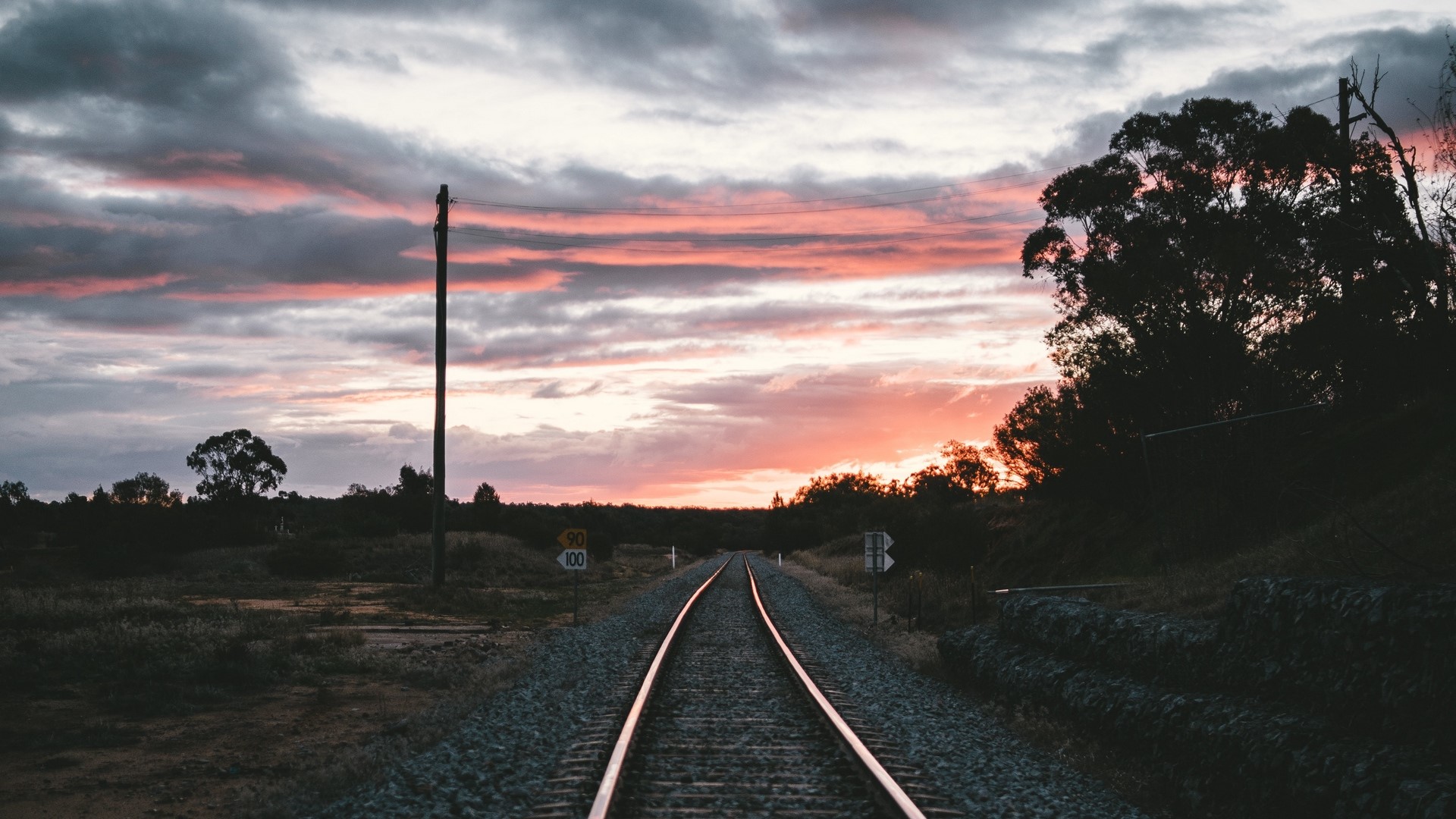 Railroad tracks at sunset with pink clouds HD Wallpaper