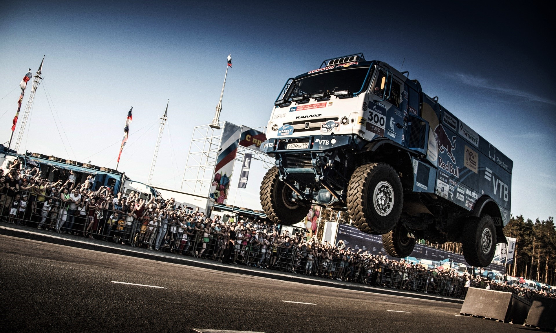 Kamaz truck jumping over a crowd at a race HD Wallpaper
