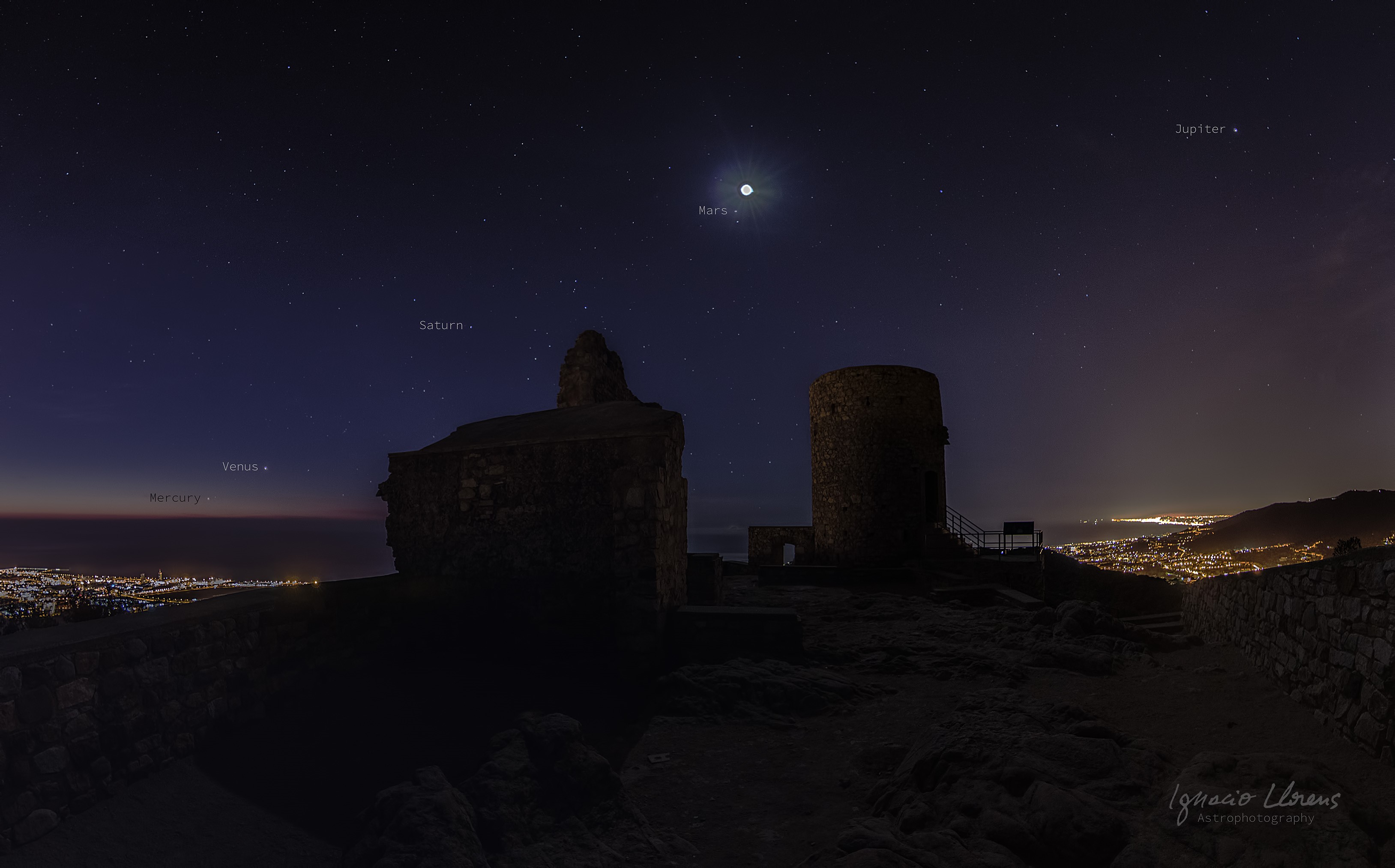 Planets visible in the night sky over ruins and a city HD Wallpaper