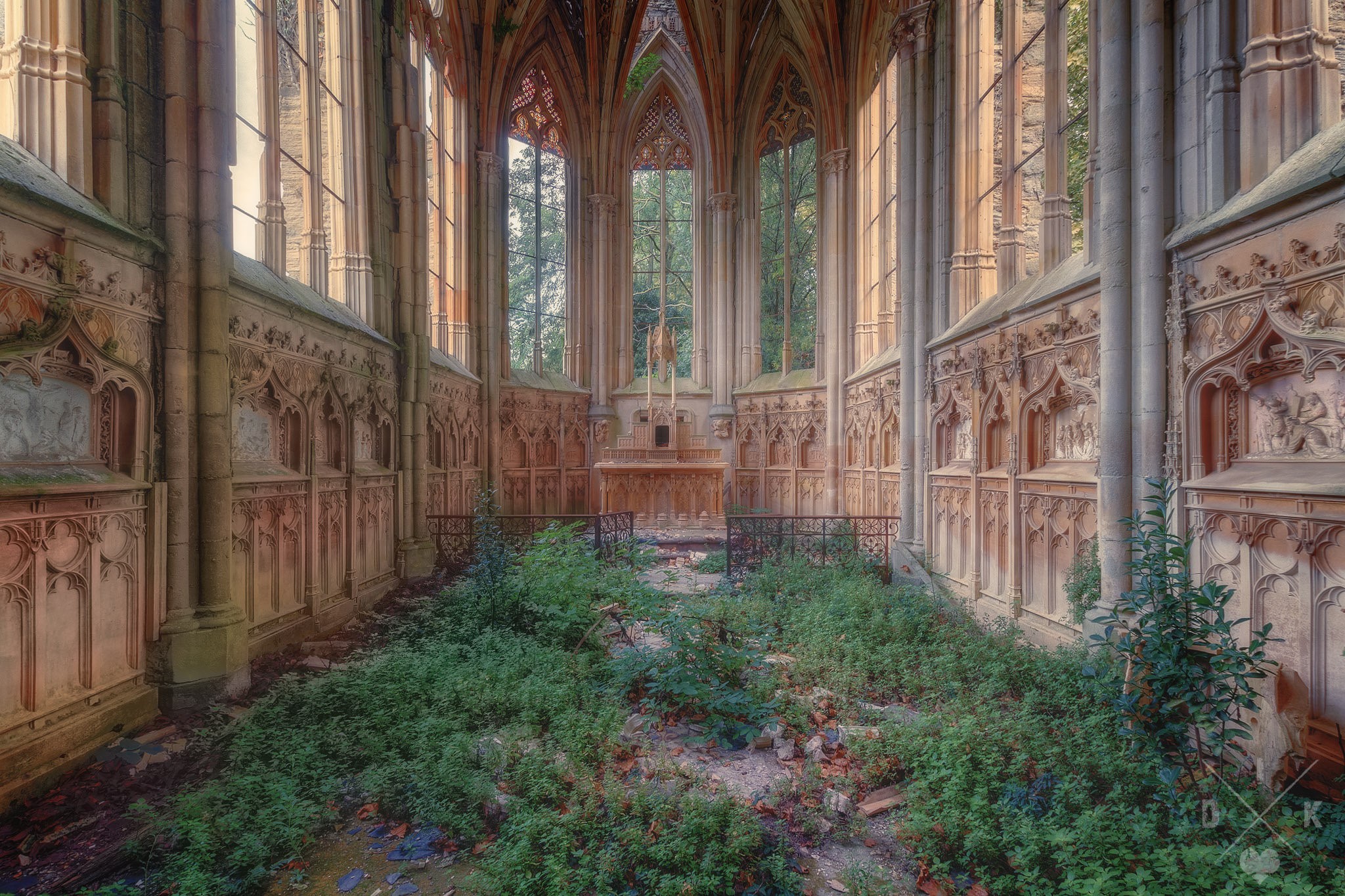 Abandoned chapel interior with overgrown plants and altar HD Wallpaper
