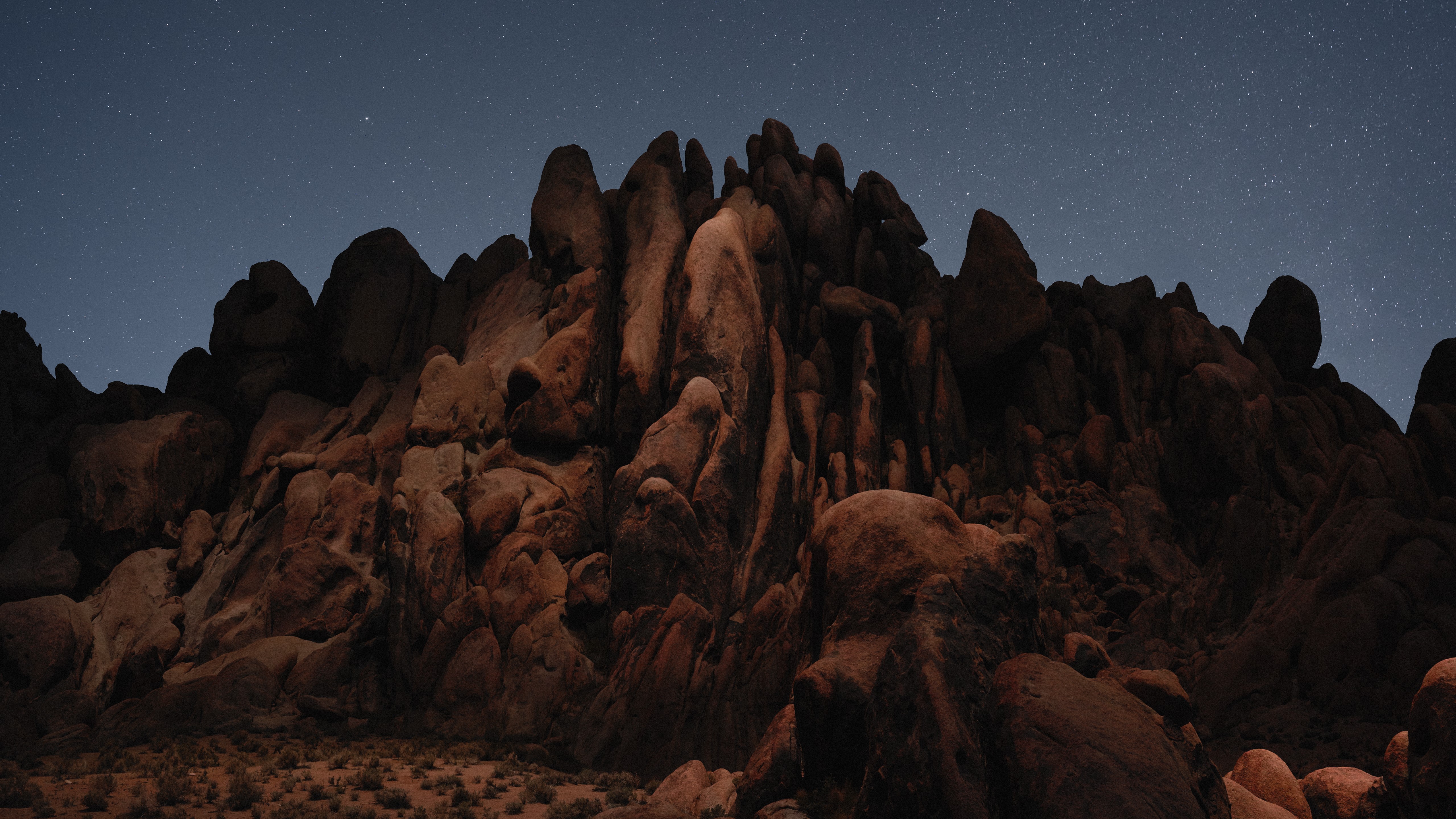 Rocky desert landscape under a starry night sky HD Wallpaper