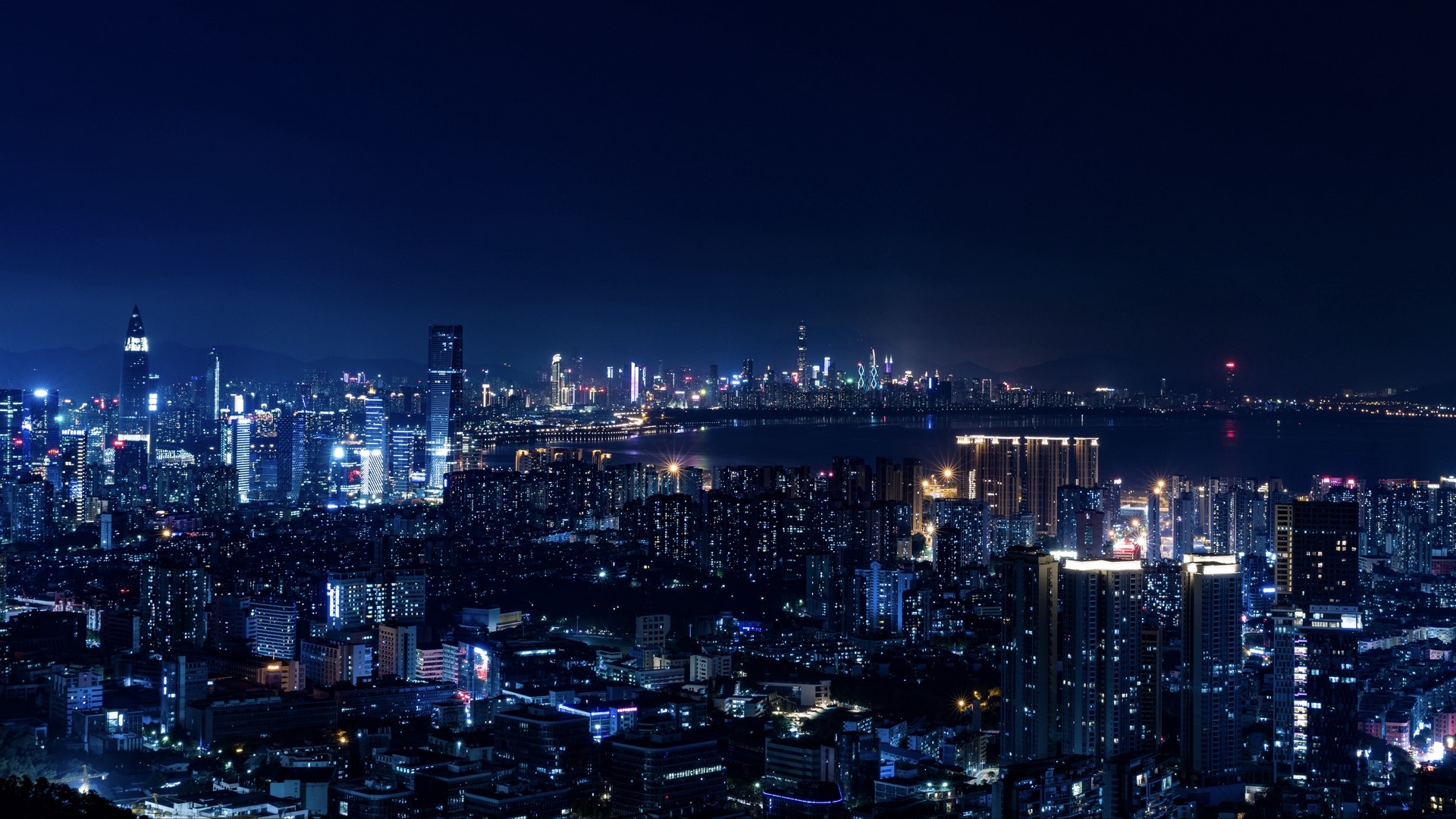 Night cityscape with illuminated skyscrapers and water HD Wallpaper