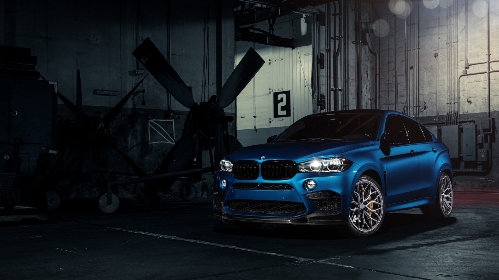 Blue BMW X6 M parked in a hangar HD Wallpaper