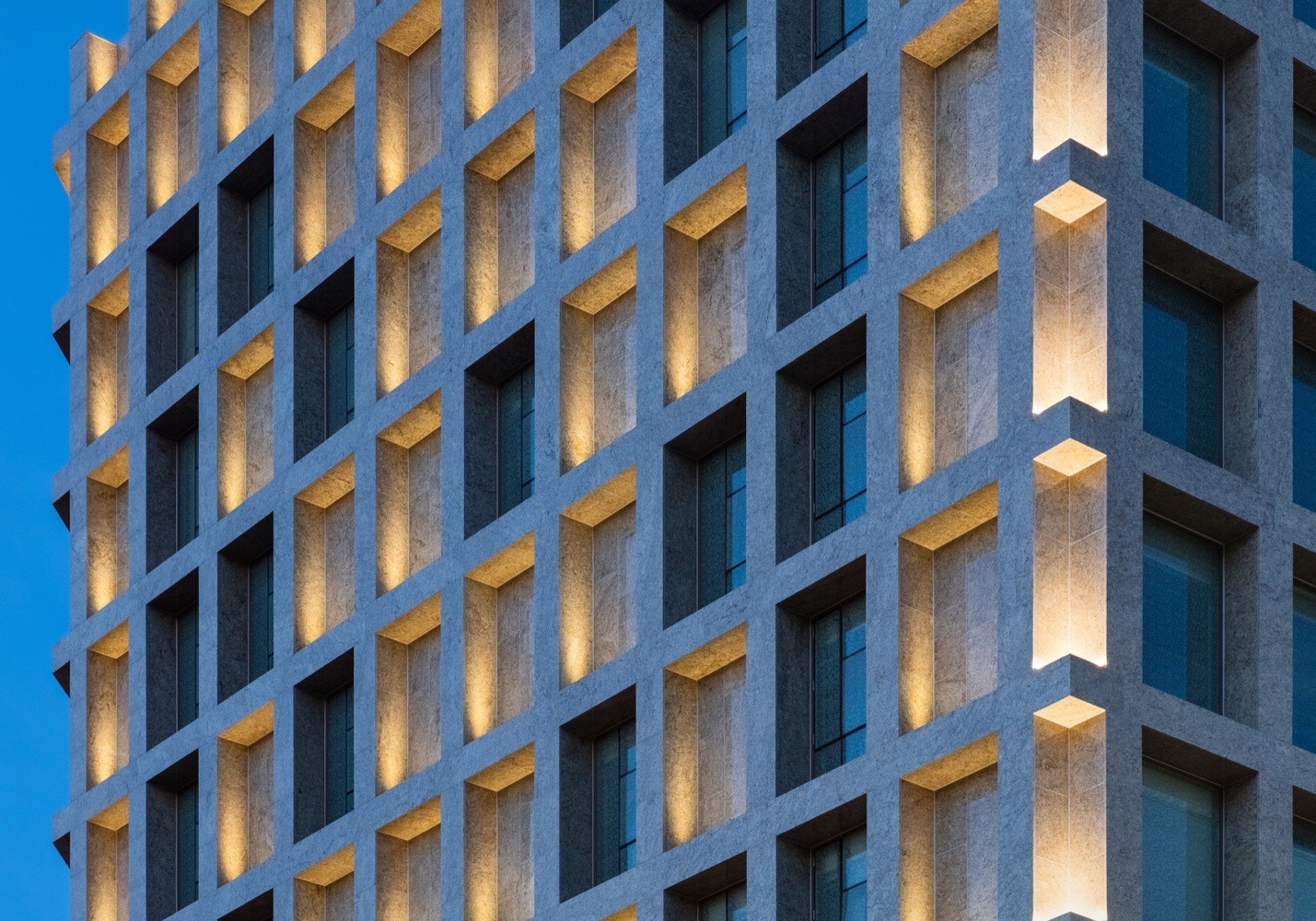 Modern building facade with illuminated windows HD Wallpaper