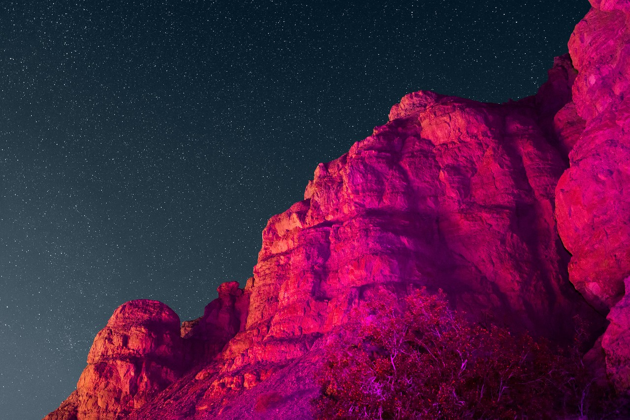 Rock formations under a starry night sky HD Wallpaper