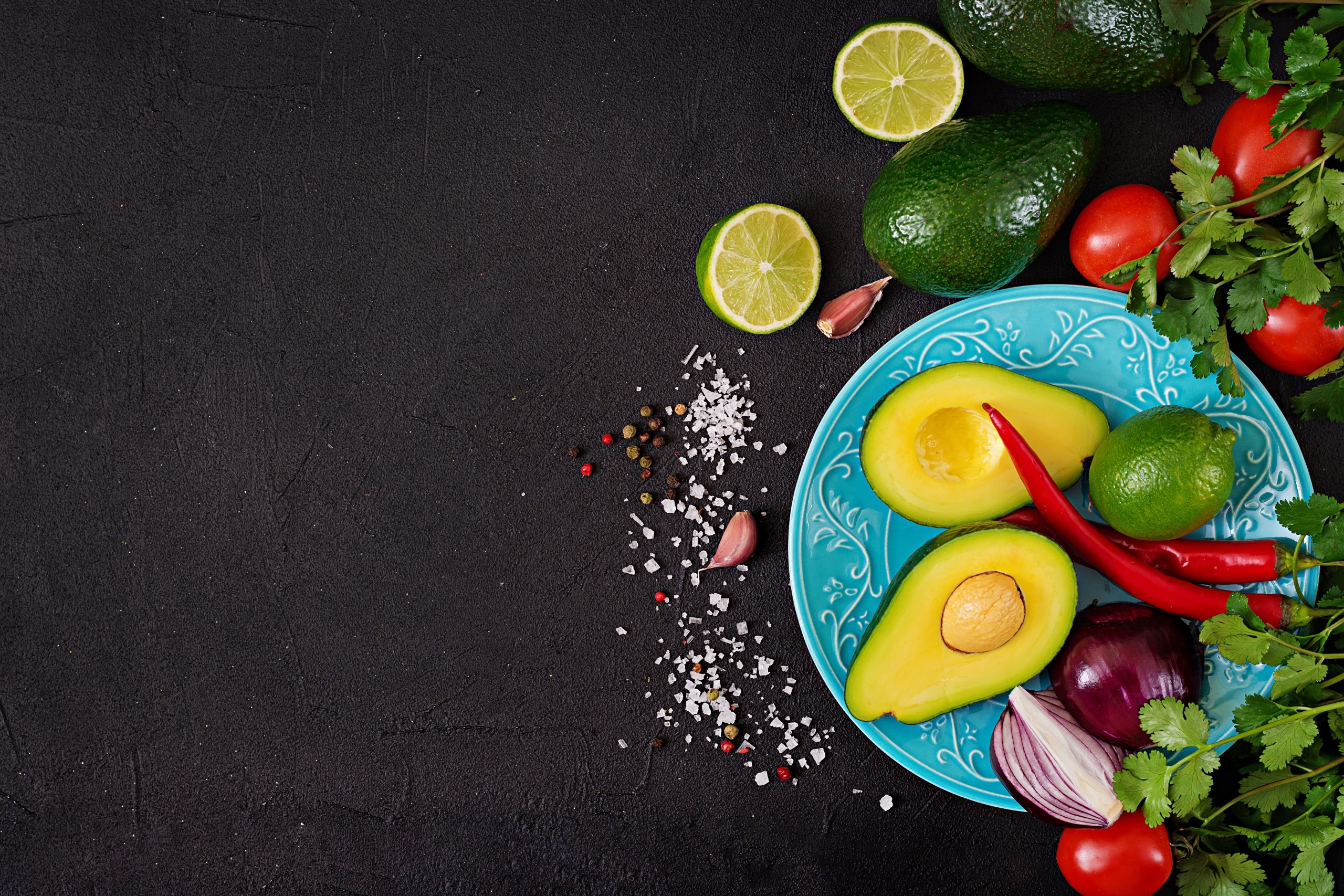 Avocado, lime, tomatoes, chili peppers, and onion on a plate HD Wallpaper
