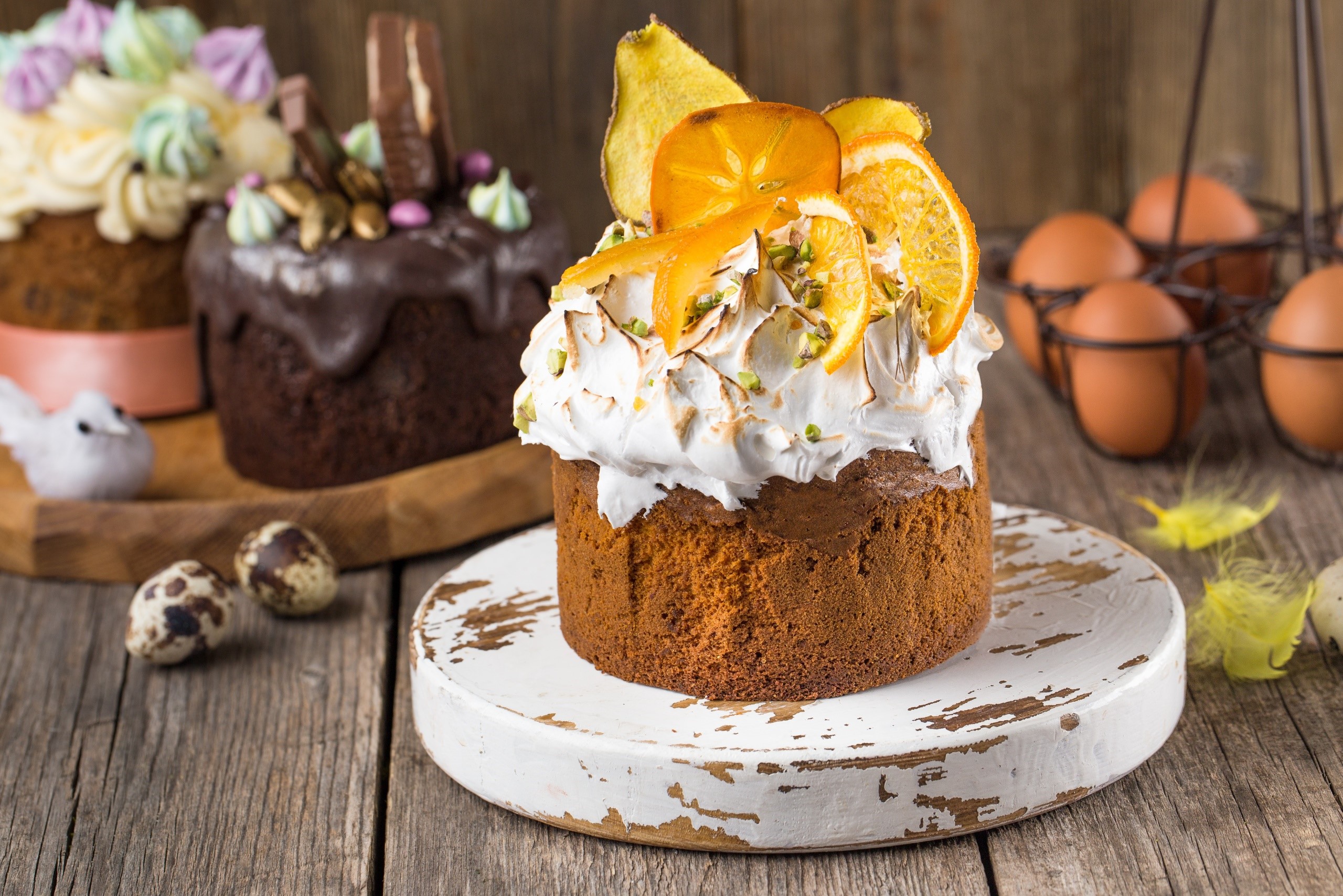 Easter cakes with meringue and fruit on a wooden table HD Wallpaper