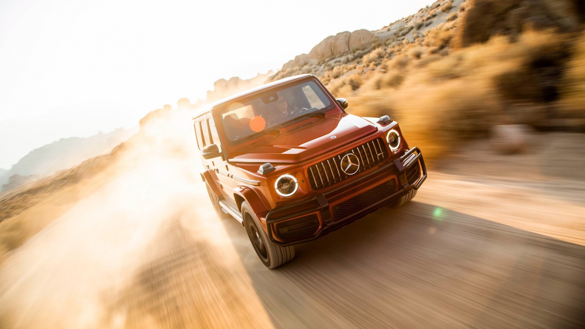 Red Mercedes-Benz G-Class driving on a dirt road HD Wallpaper