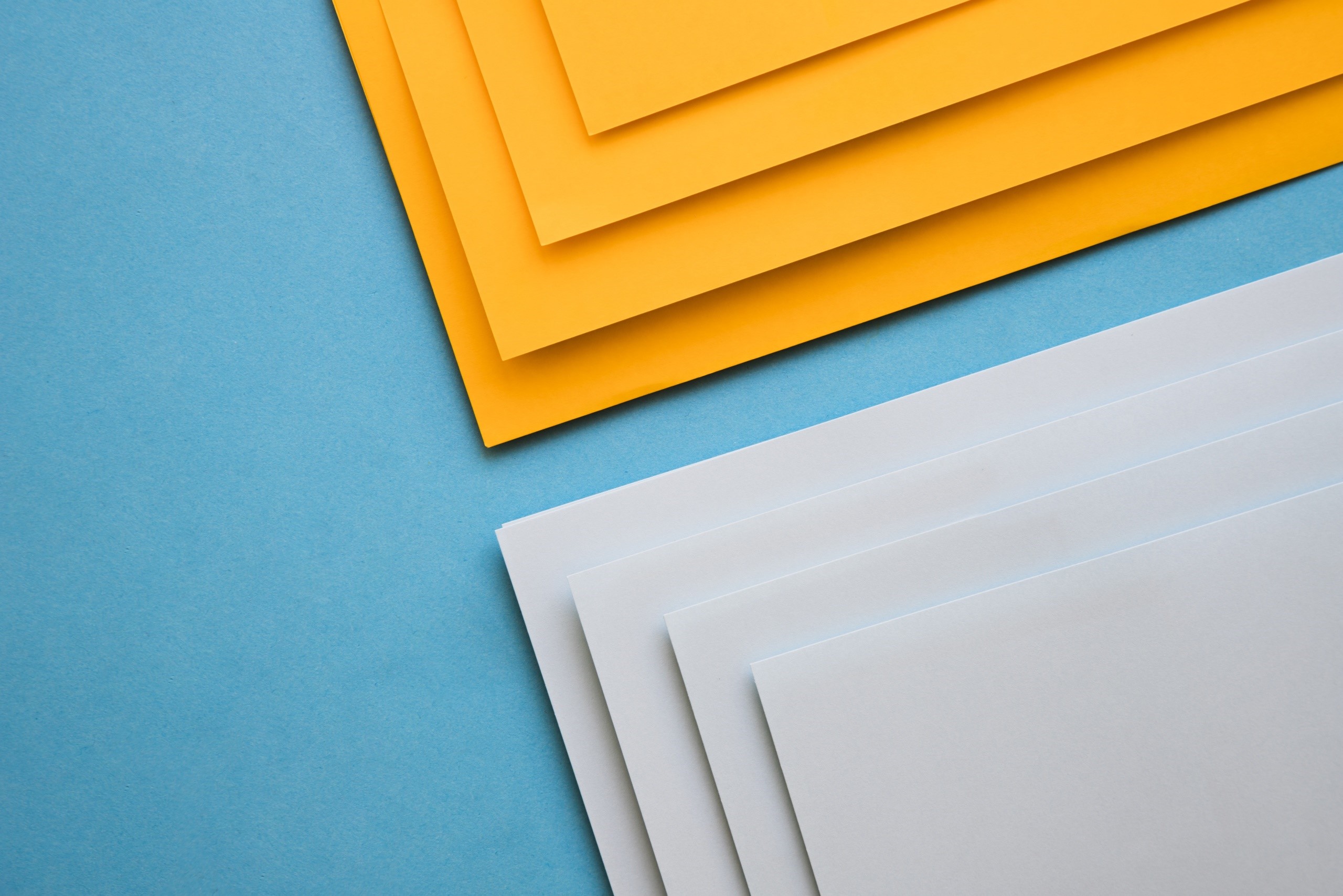 Abstract geometric arrangement of orange and white paper on blue background HD Wallpaper