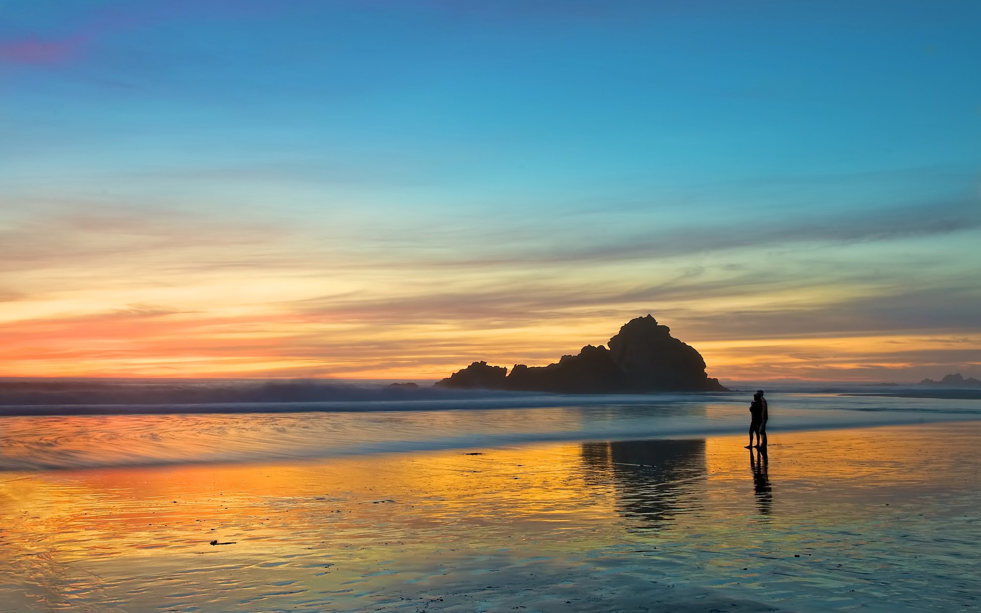 Couple silhouetted on a beach at sunset HD Wallpaper