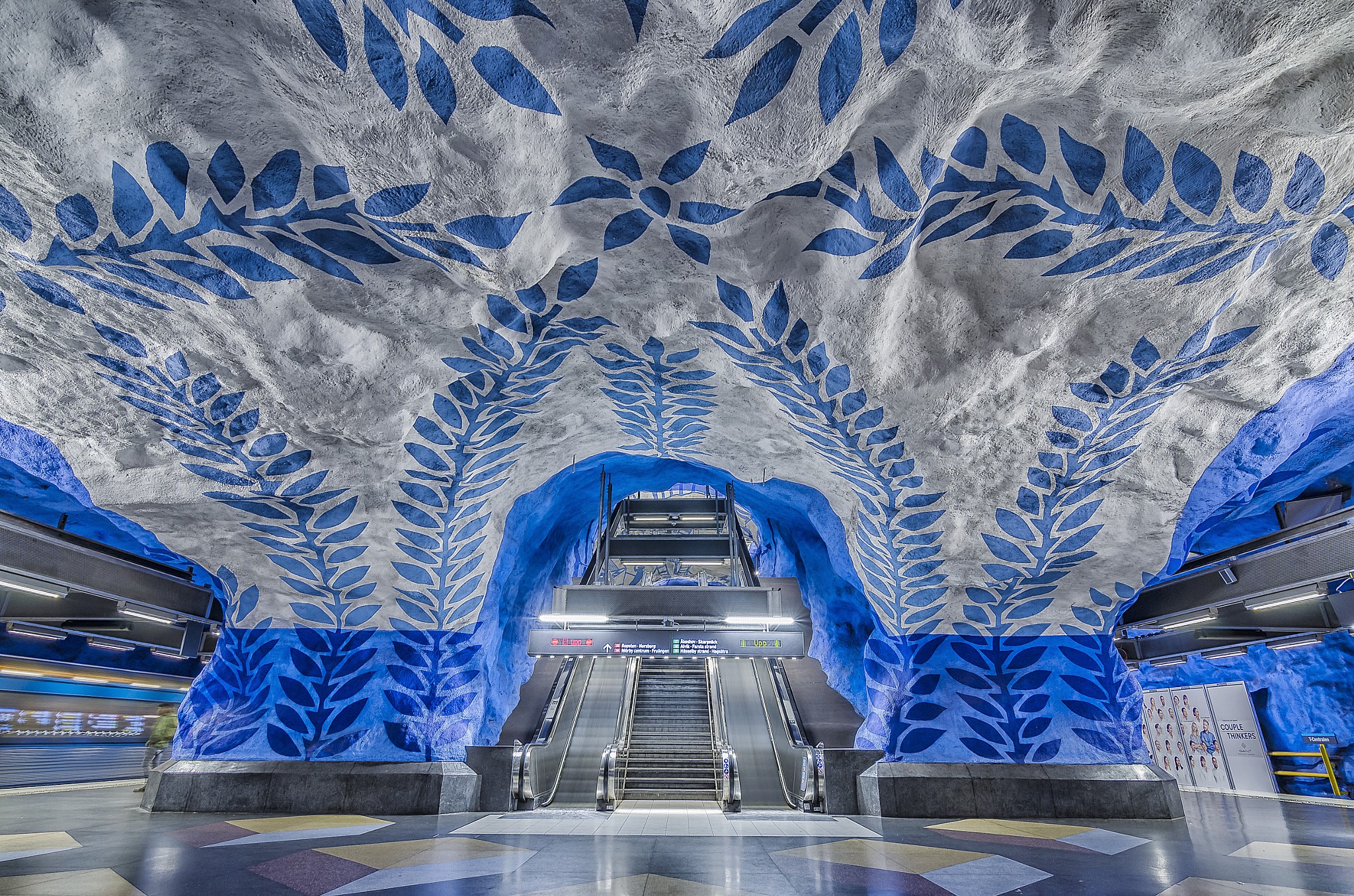 Stockholm Metro station with blue leaf art and escalators HD Wallpaper