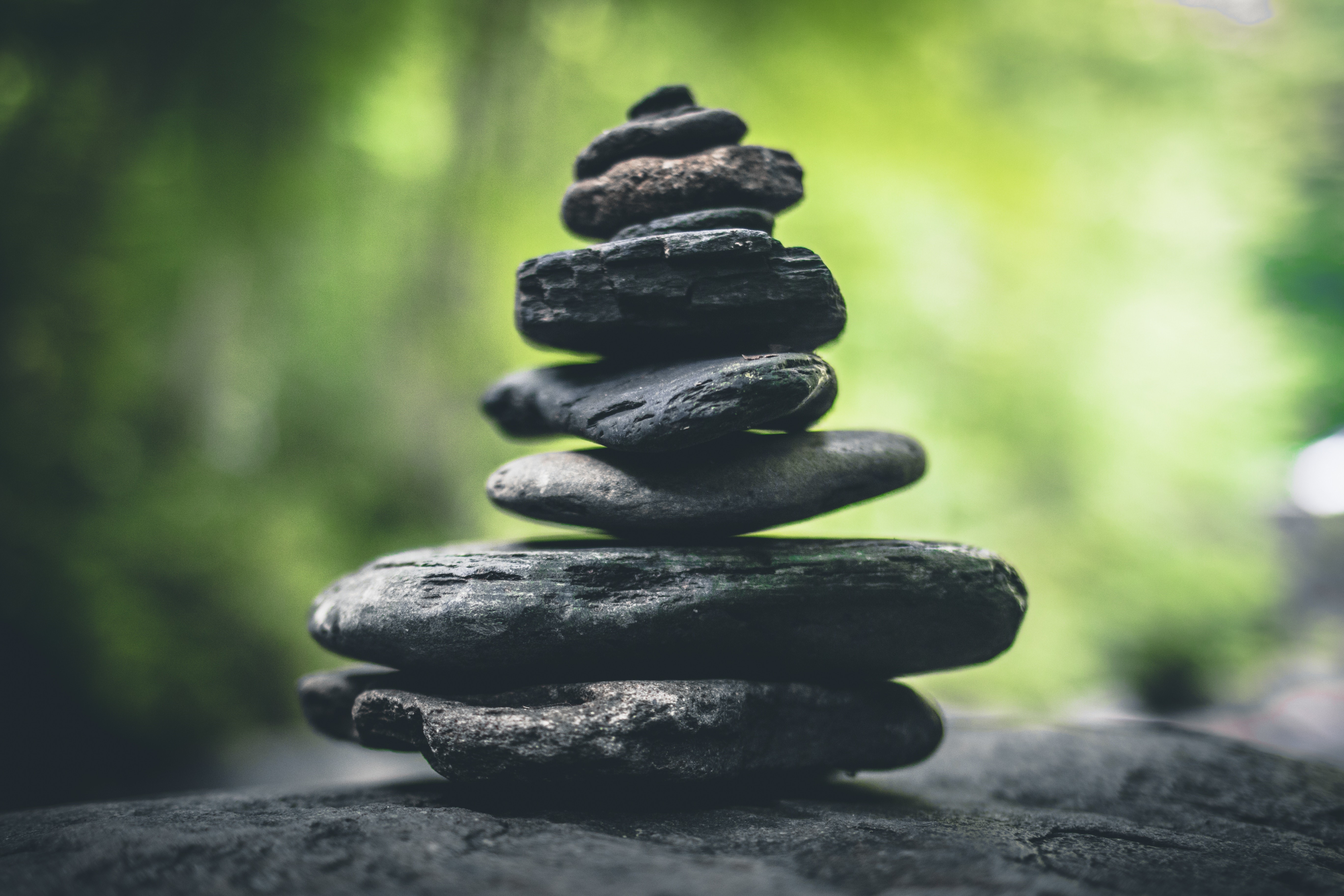 Stack of gray stones outdoors with green background HD Wallpaper