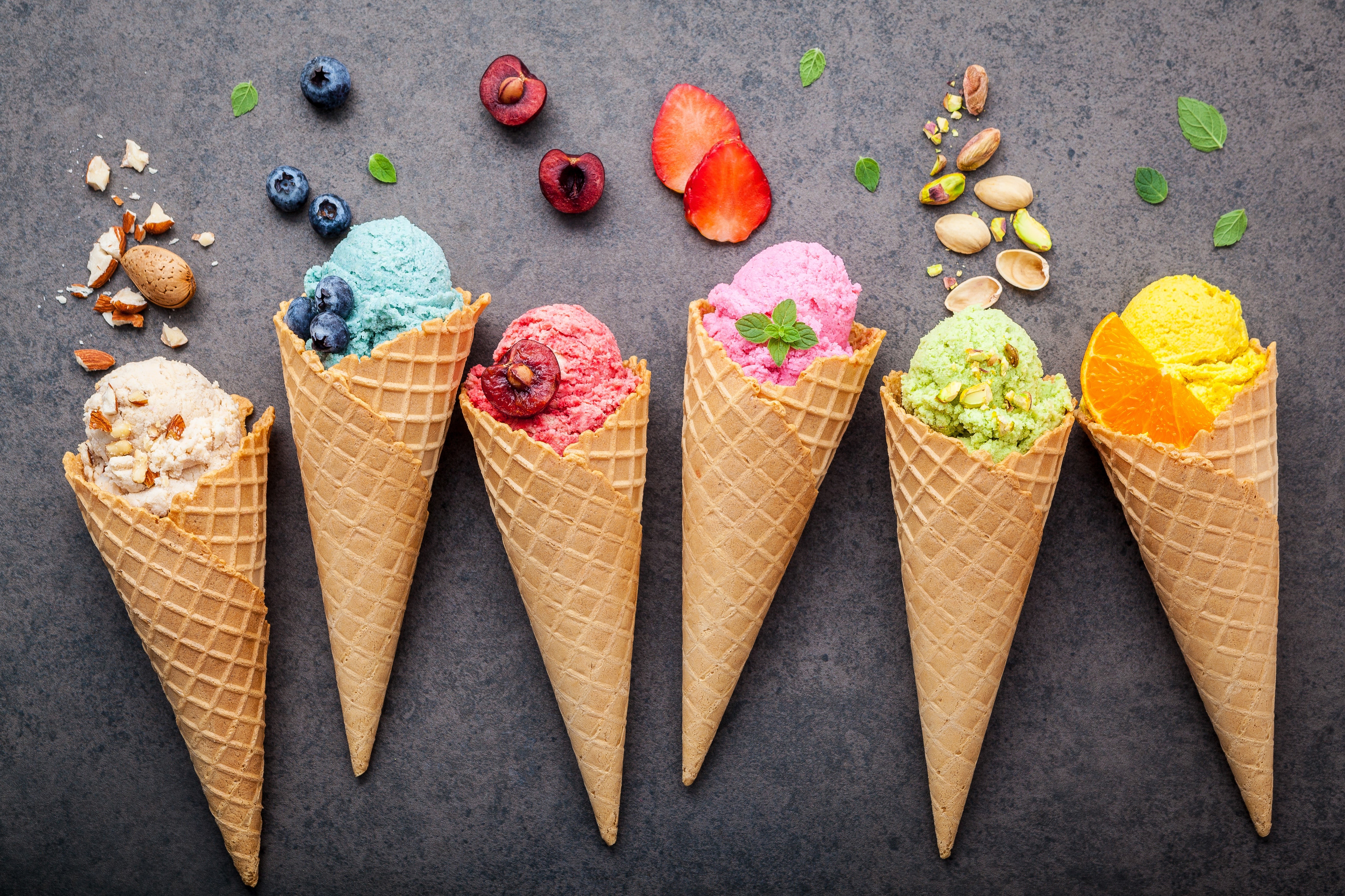 Colorful ice cream cones with fruits and nuts, top view HD Wallpaper