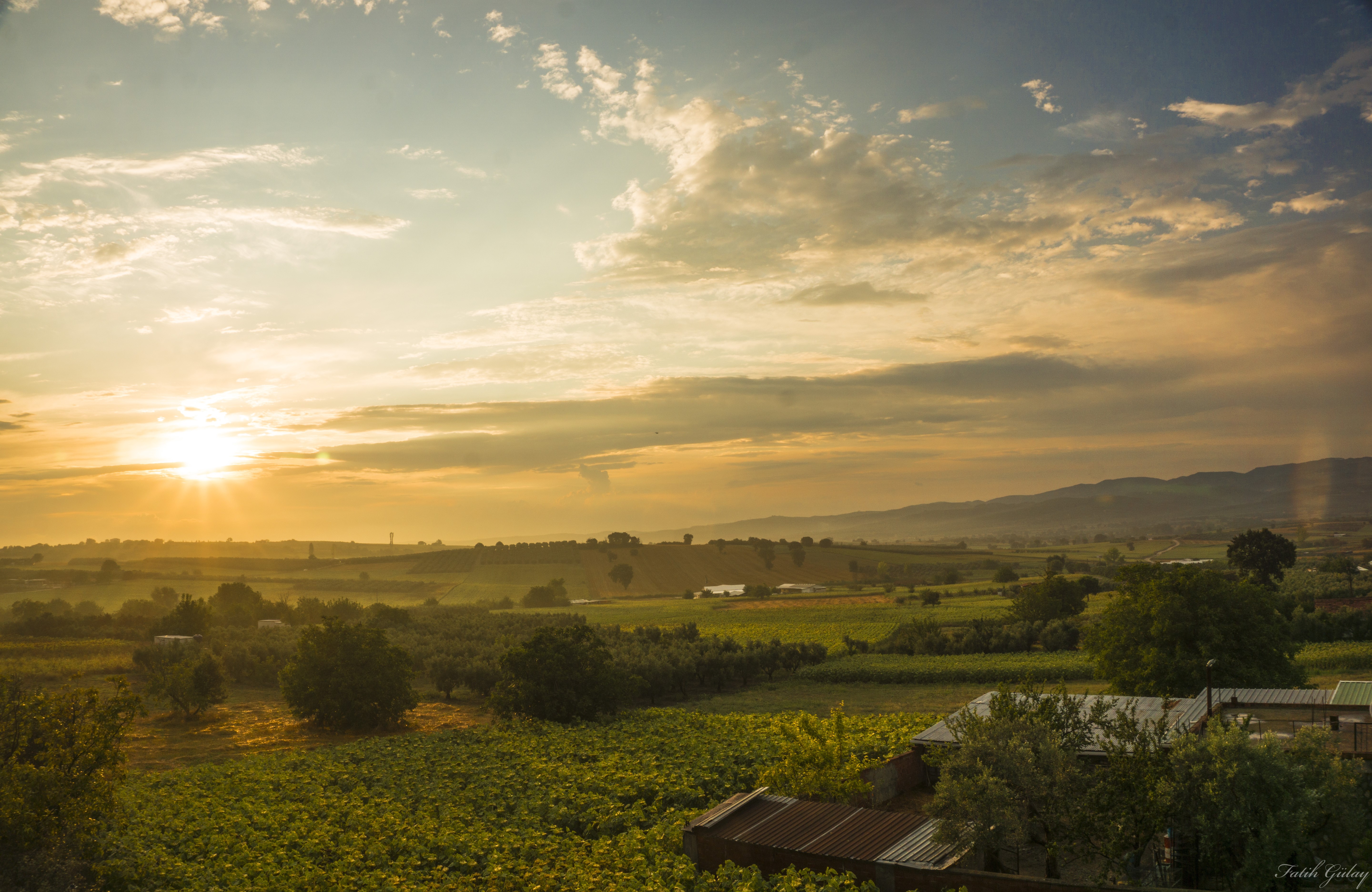 Sunset over a rural landscape with farms and fields HD Wallpaper
