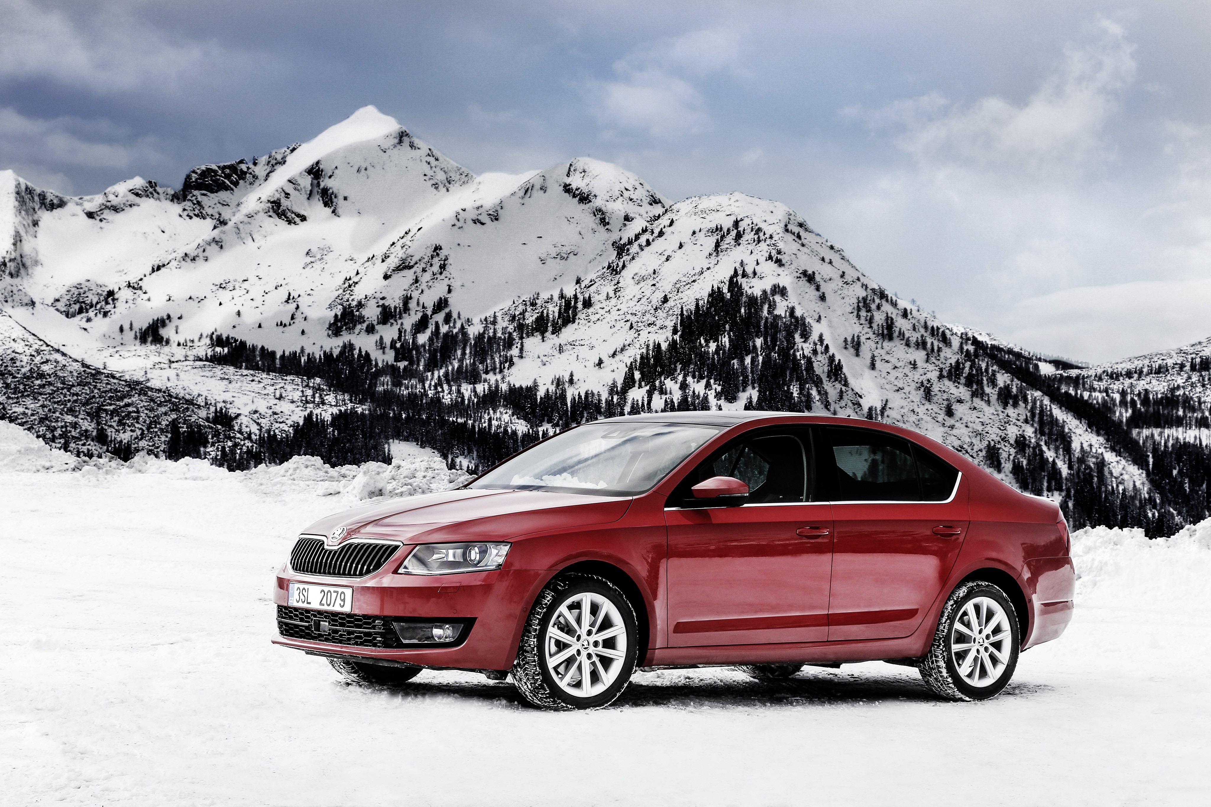 Red Skoda car in snowy mountains HD Wallpaper
