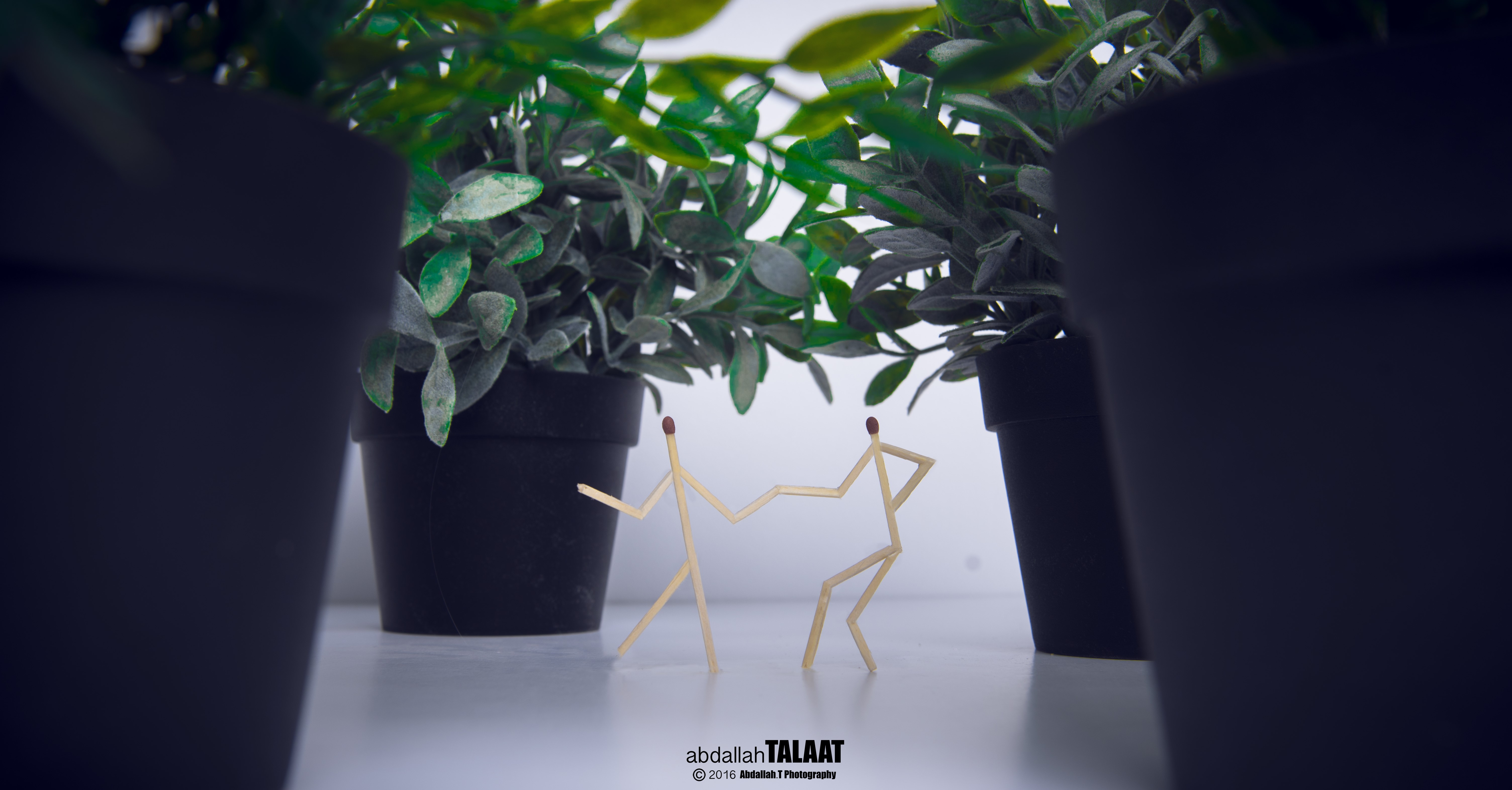 Matchstick figures dancing between potted plants HD Wallpaper