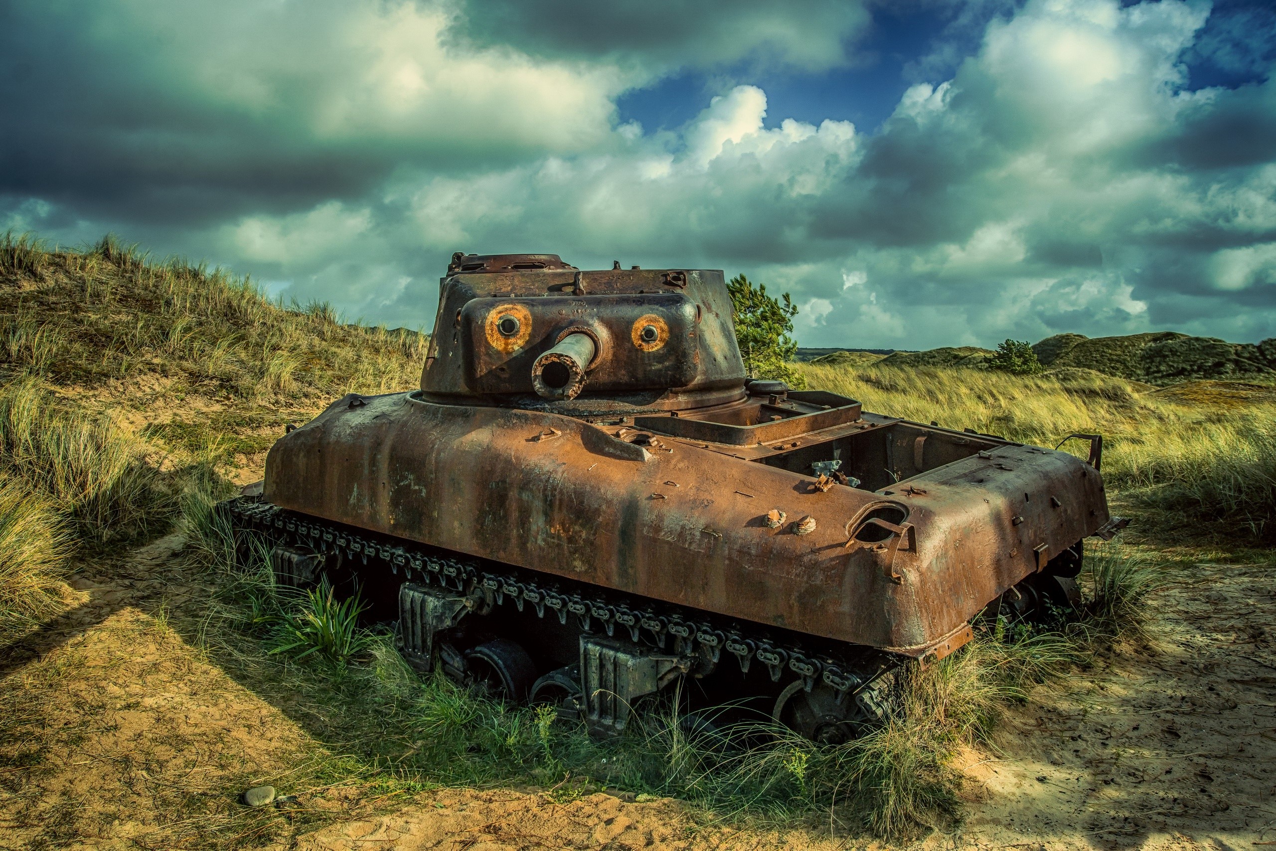 Abandoned rusty tank in grassy dunes HD Wallpaper
