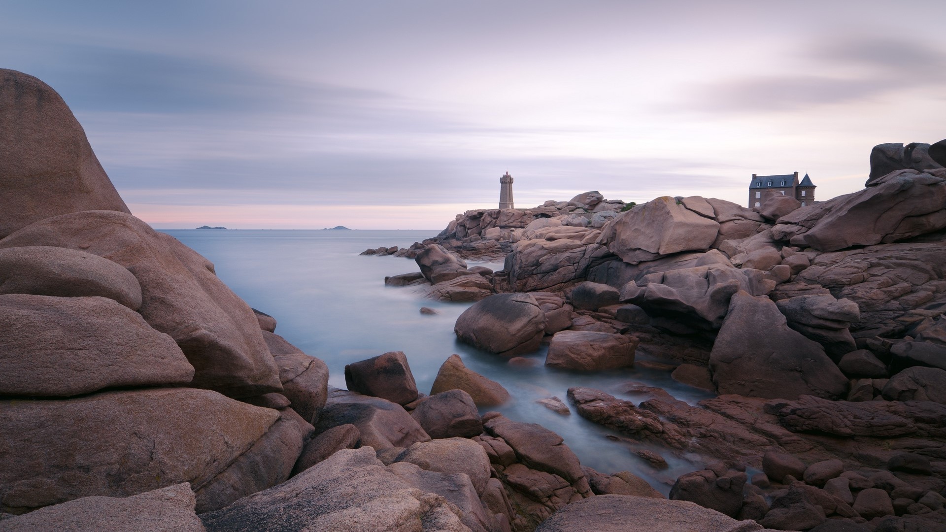 Rocky coastline with lighthouse and building HD Wallpaper
