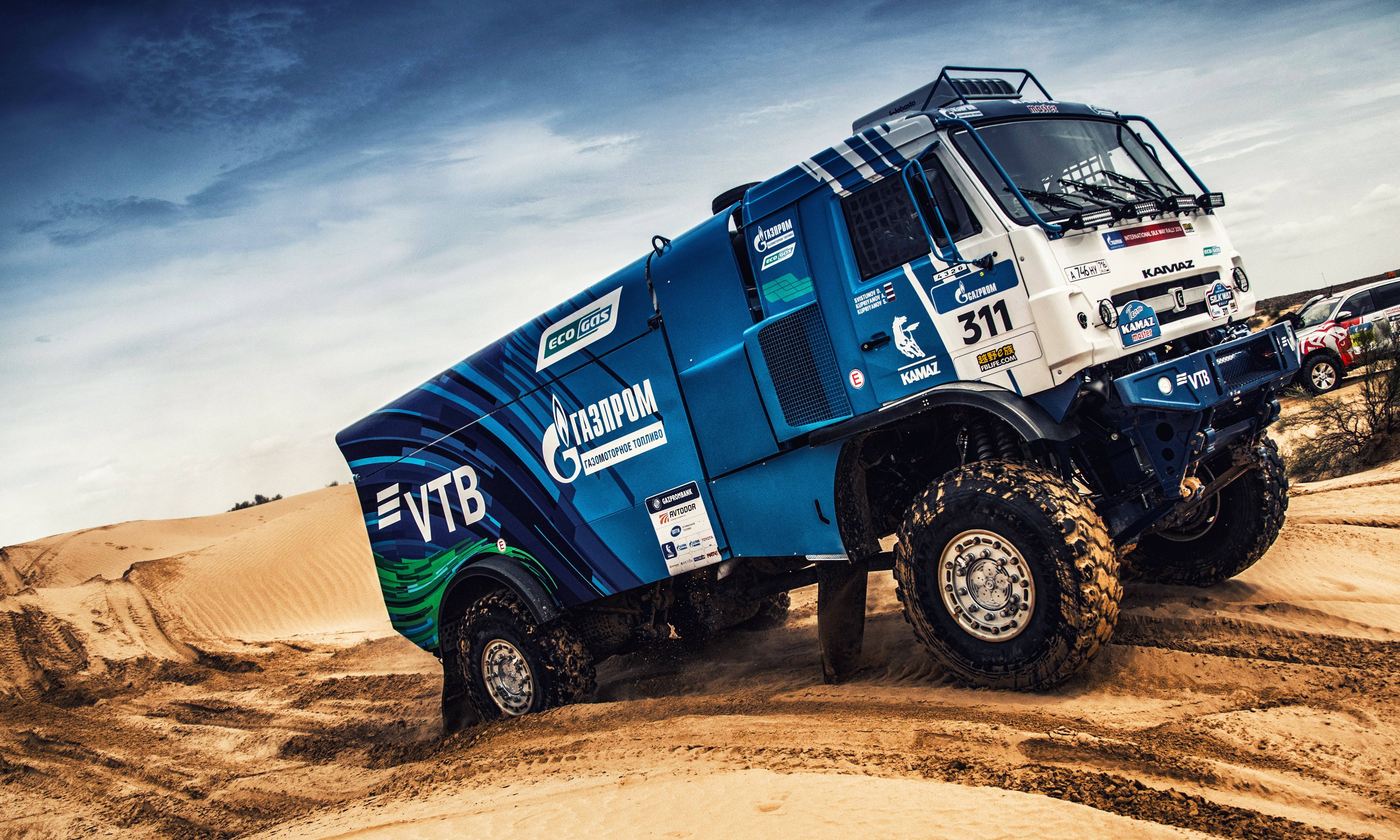Kamaz rally truck driving through desert dunes HD Wallpaper
